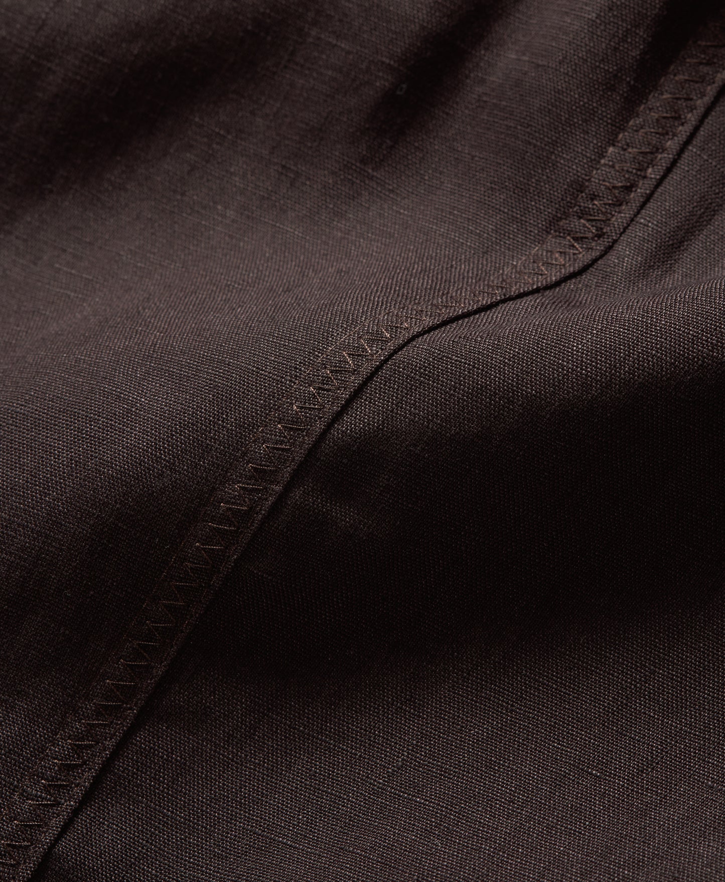Close-up of dark brown fabric with visible stitching