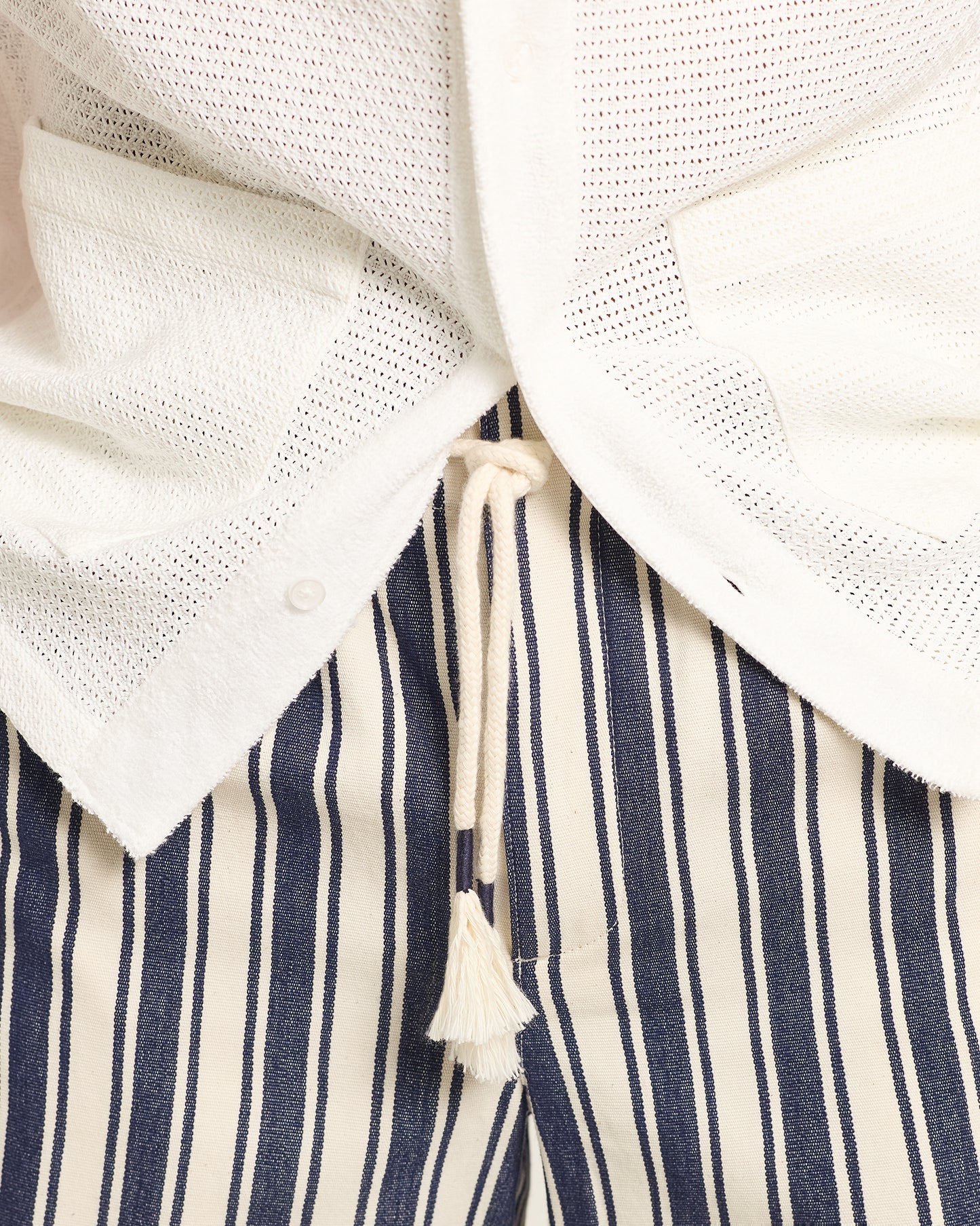 Close-up of a navy and white striped garment with a drawstring.