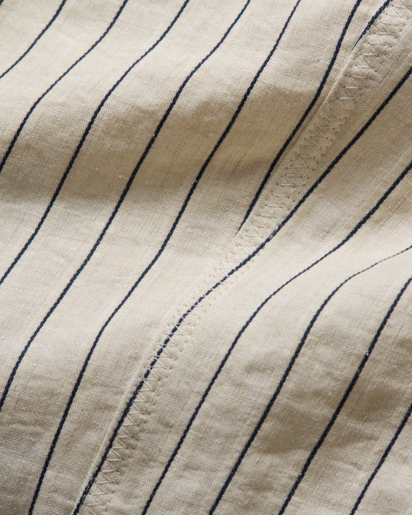 Close-up of beige fabric with blue vertical stripes