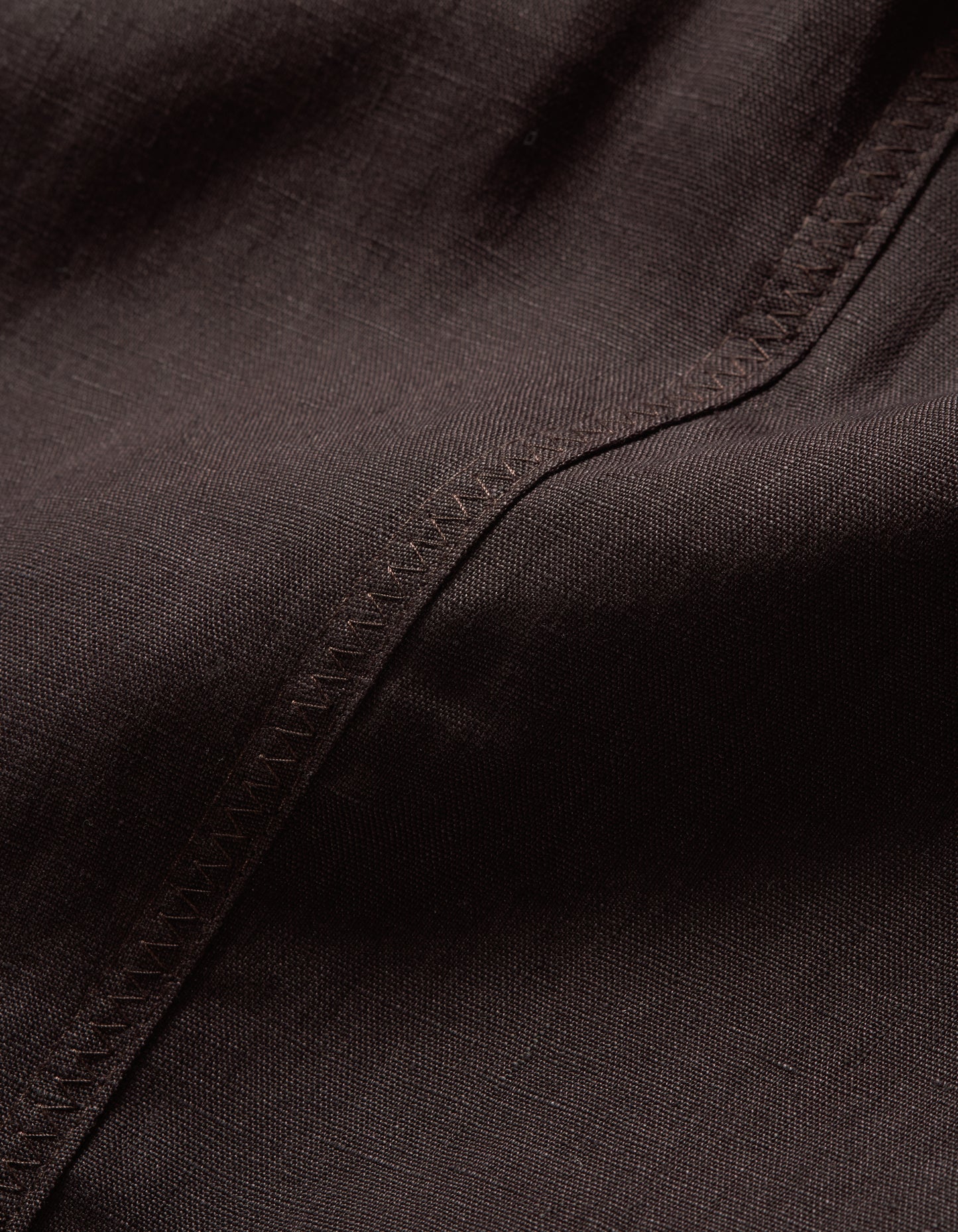 Close-up of dark brown fabric with visible stitching
