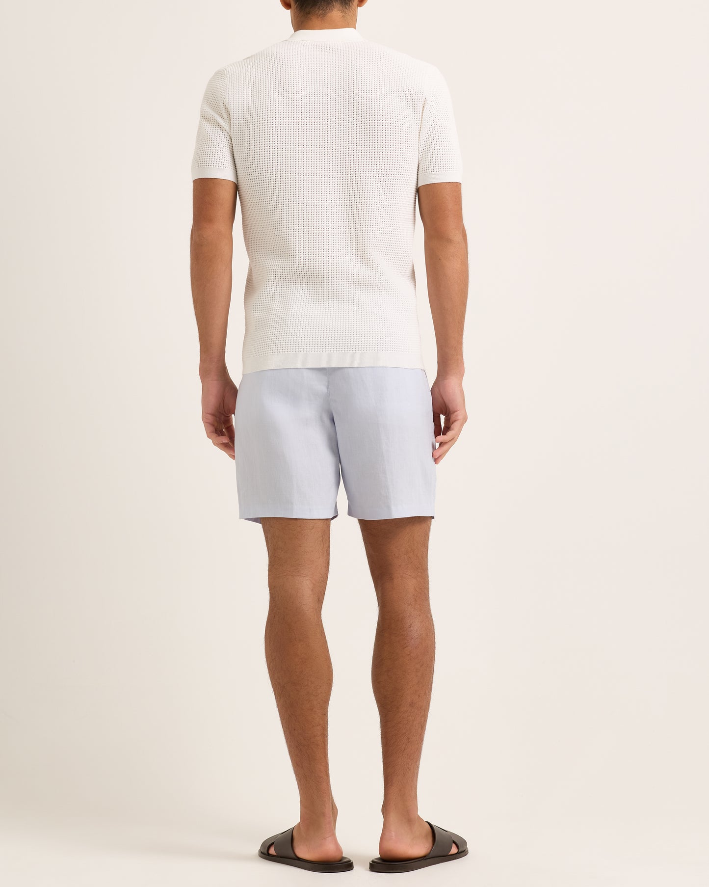 Light blue shorts with a tie waist worn by a person, featuring a white textured polo.