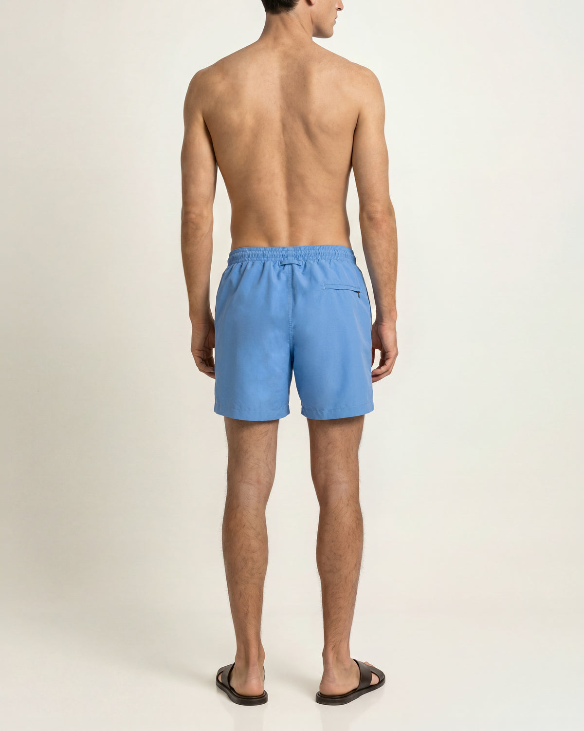 Man wearing bright blue swim short with drawcord waist on a plain background
