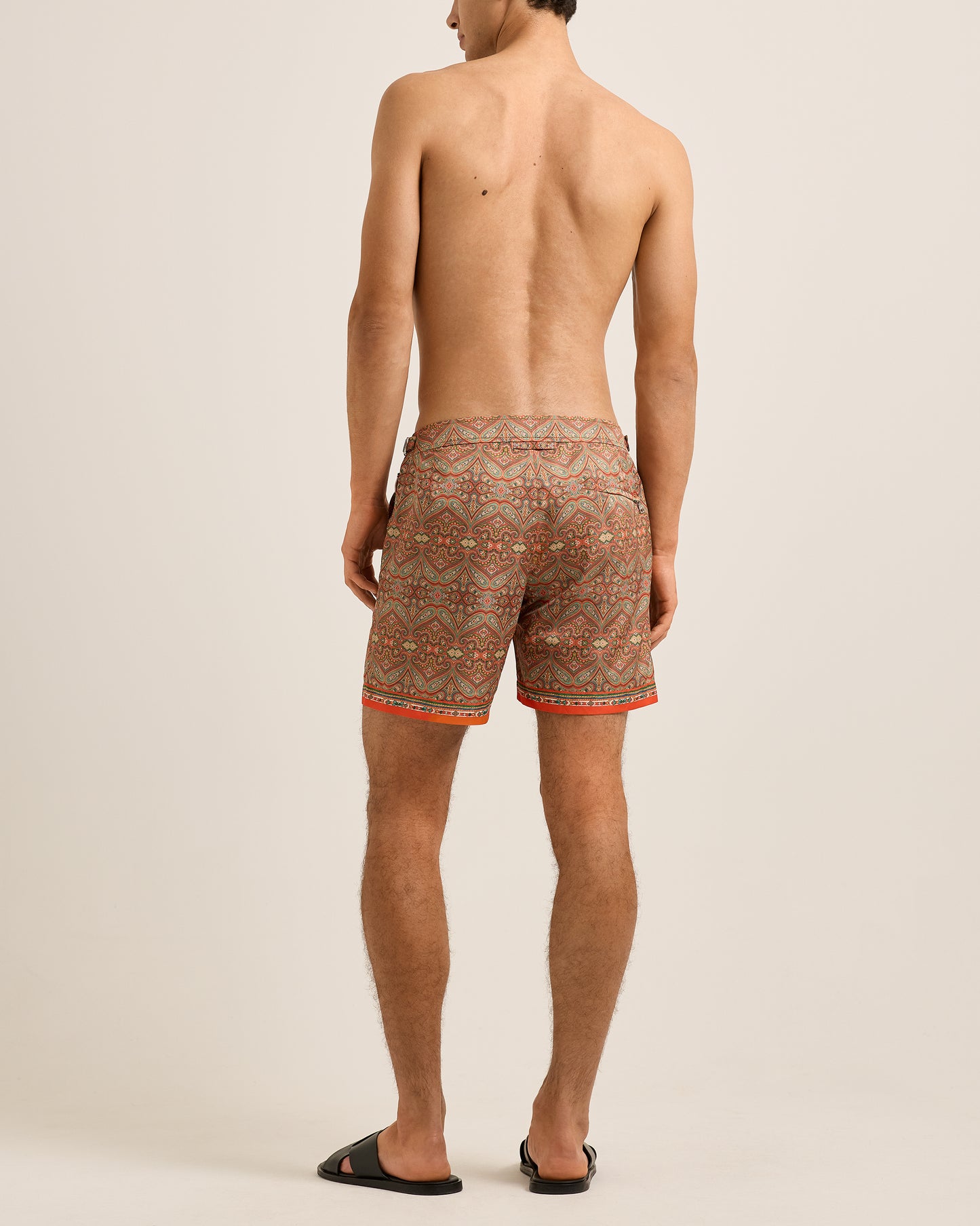 Man wearing patterned shorts on a plain background