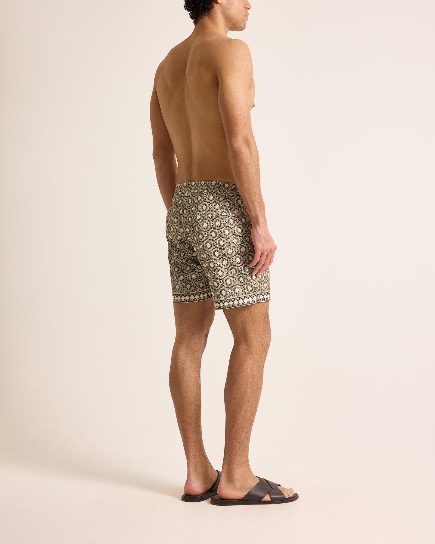 Man wearing patterned shorts on a plain background