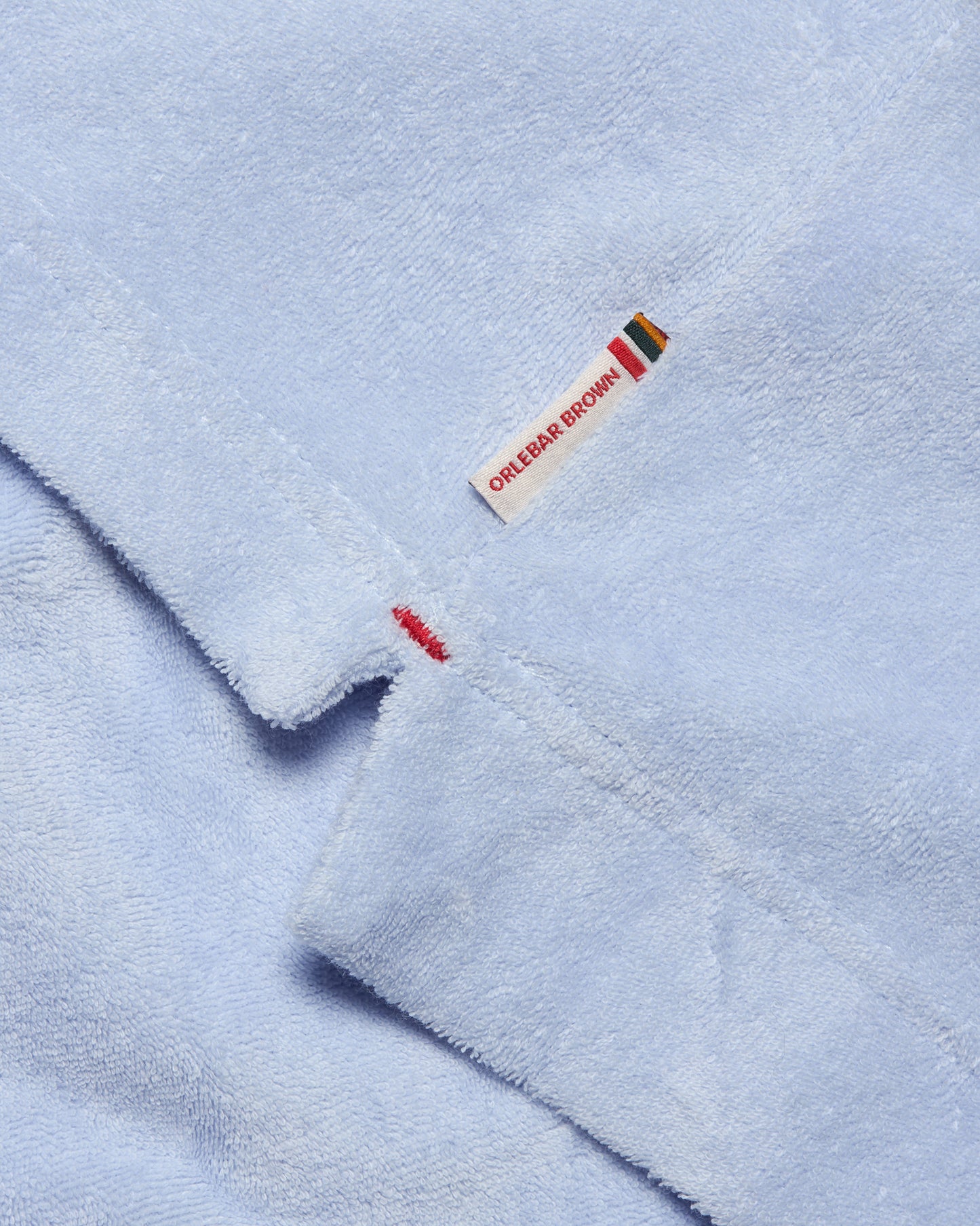 Light blue fabric with a brand label on a light blue background