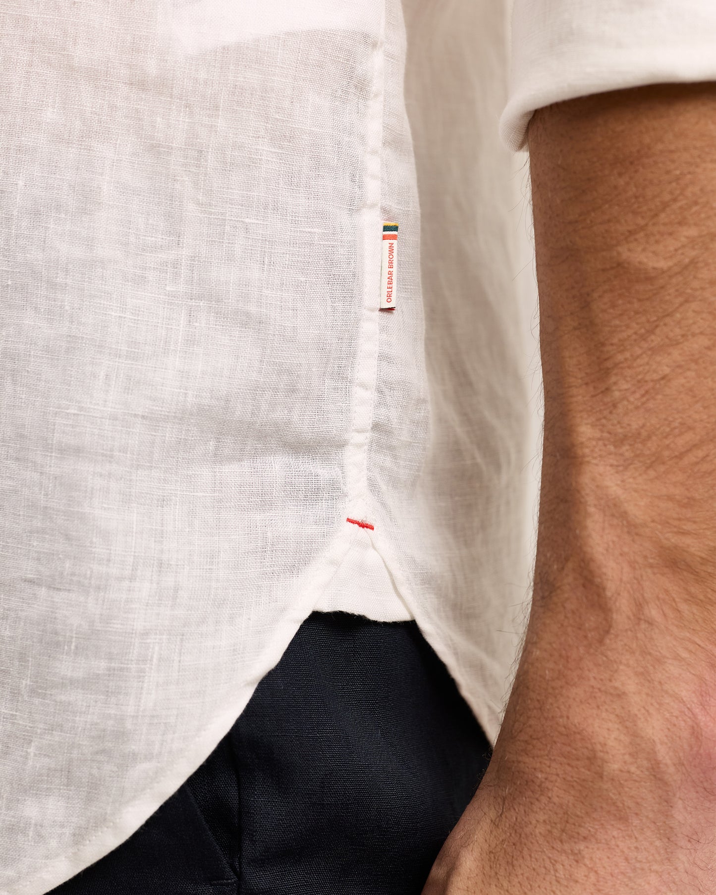 Detail of white line shirt with Orlebar Brown tag on side seam