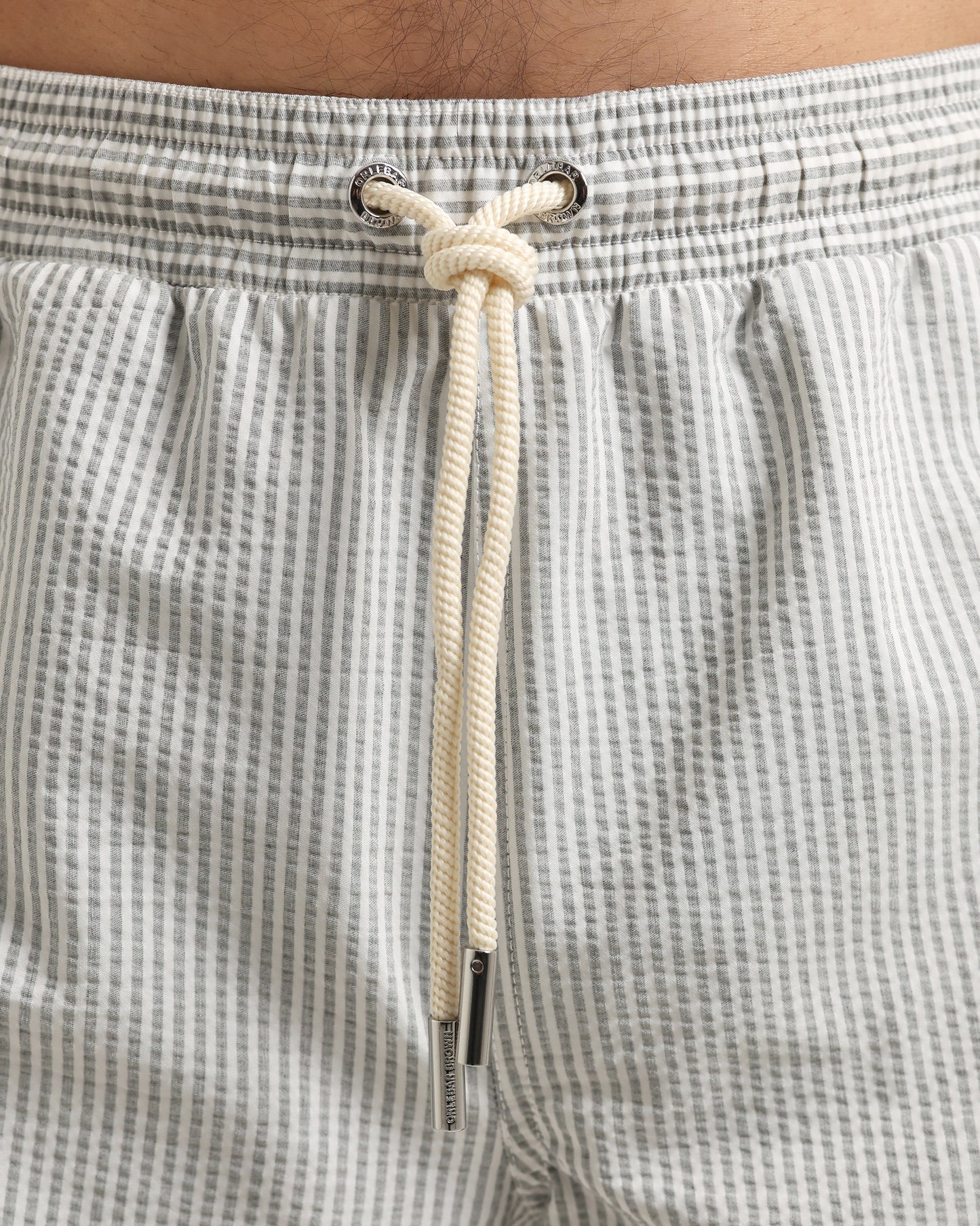 Close-up of checkered shorts with a drawstring and brand logo.