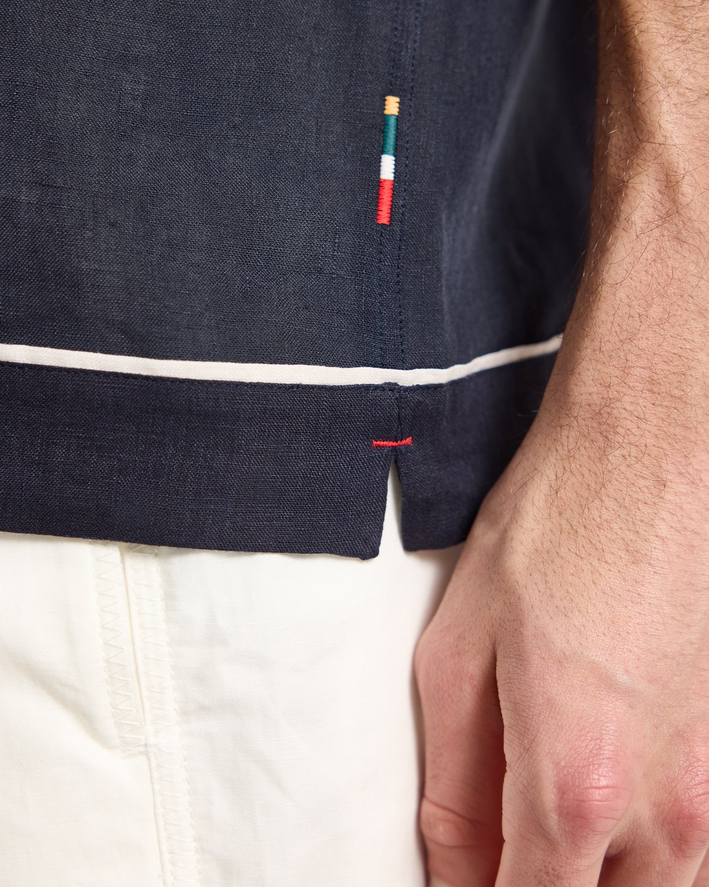 Navy shirt with a small embroidered logo on a white background