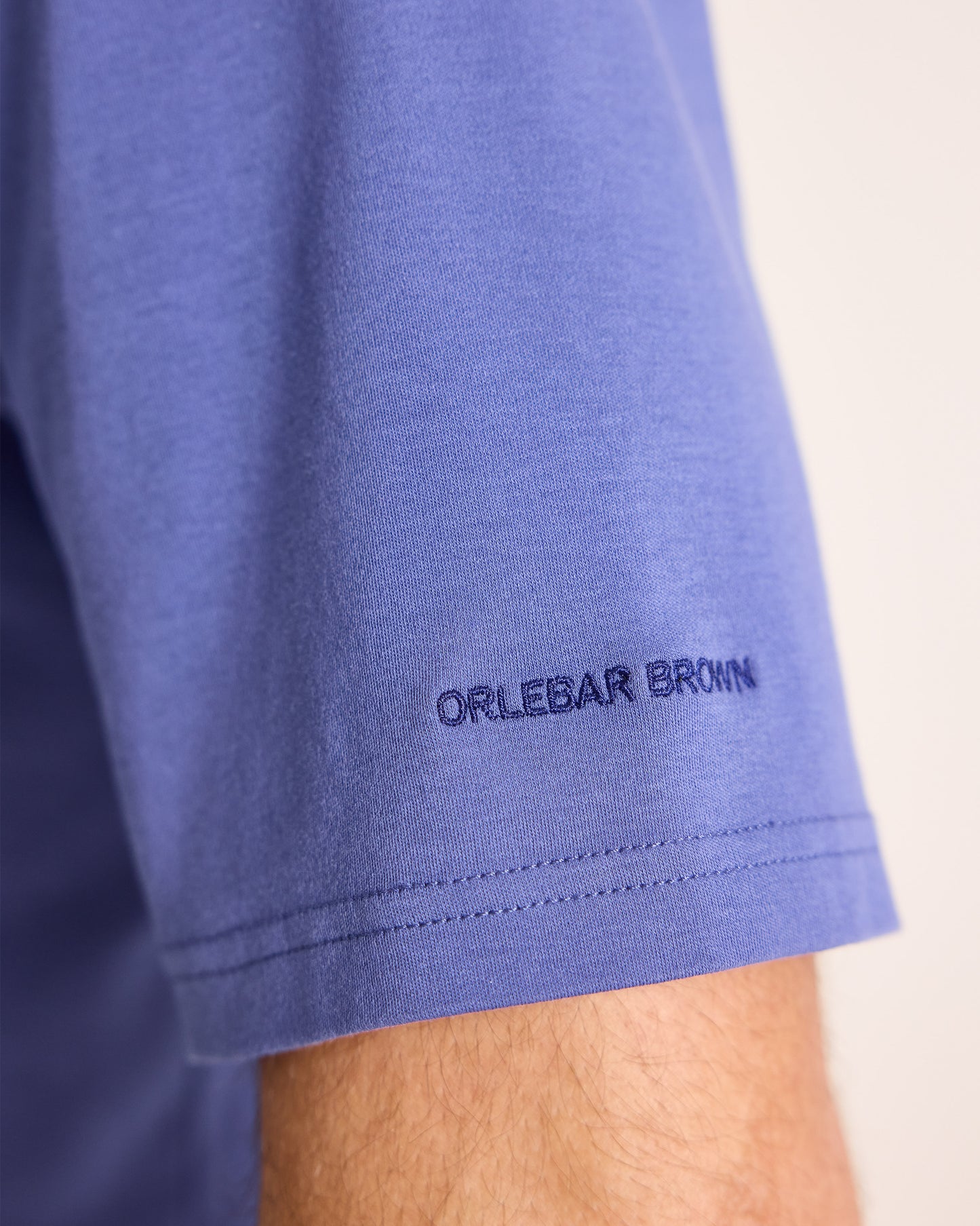 Close-up of a blue garment with 'Orlebar Brown' branding on a light background