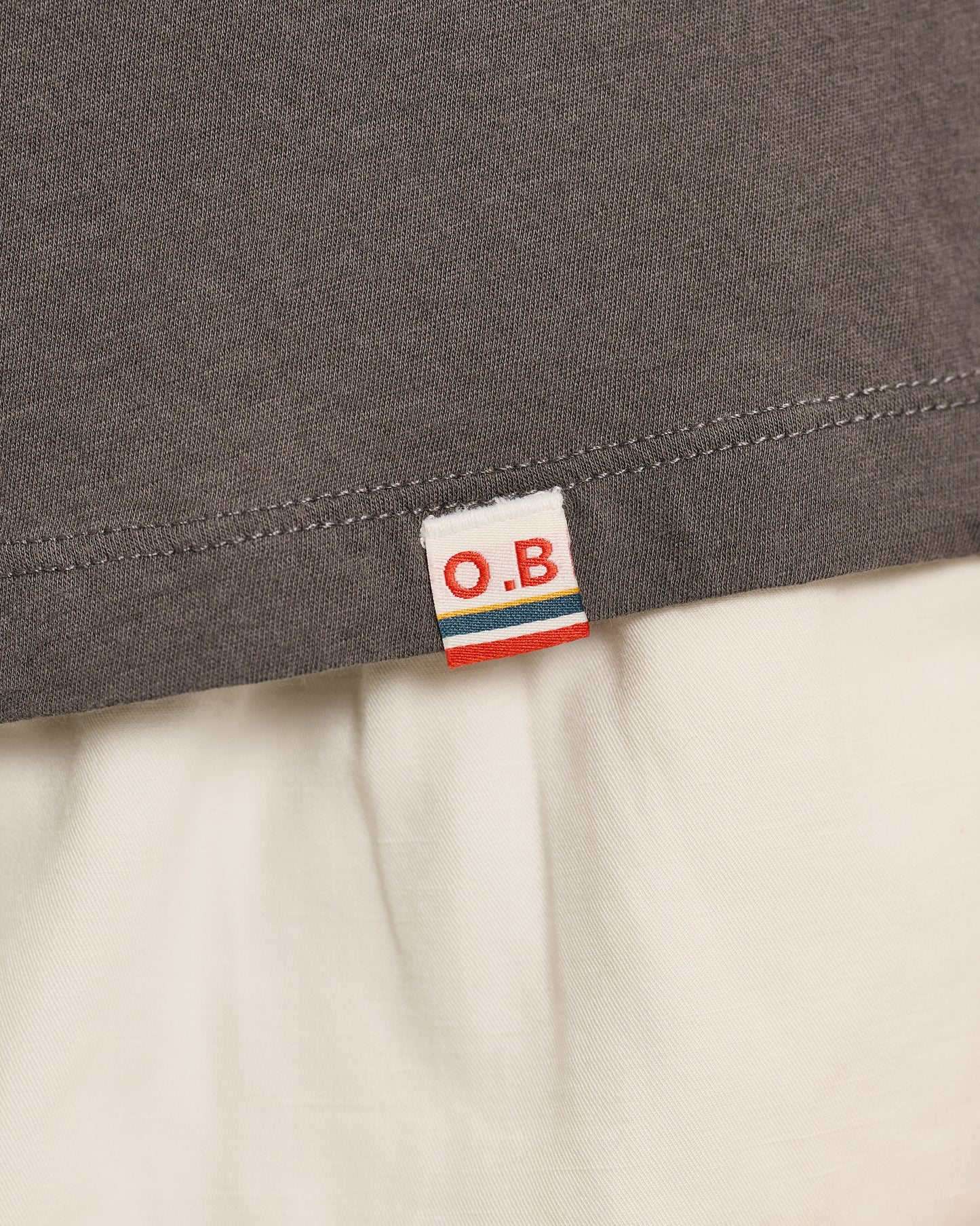 Close-up of a gray fabric with an O.B. label on a beige background