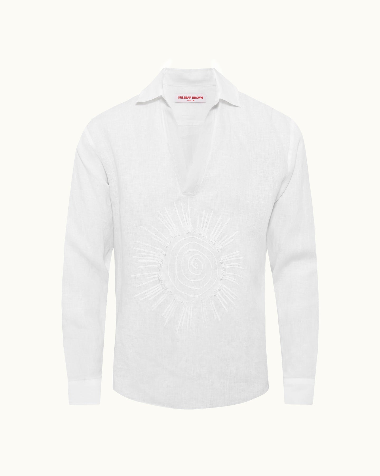 White shirt with sun embroidery on a plain background