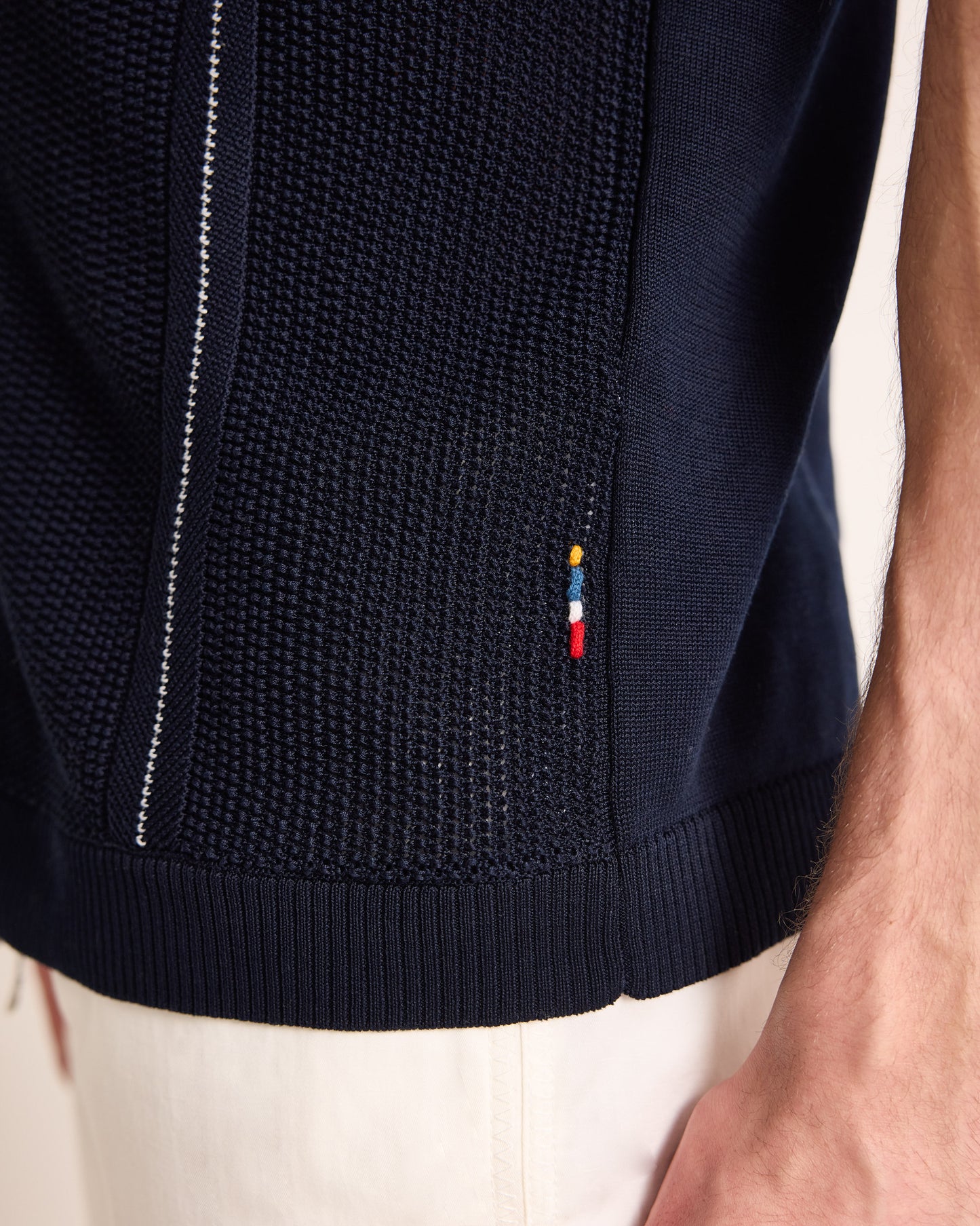 Navy blue textured jacket with brand logo on a neutral background