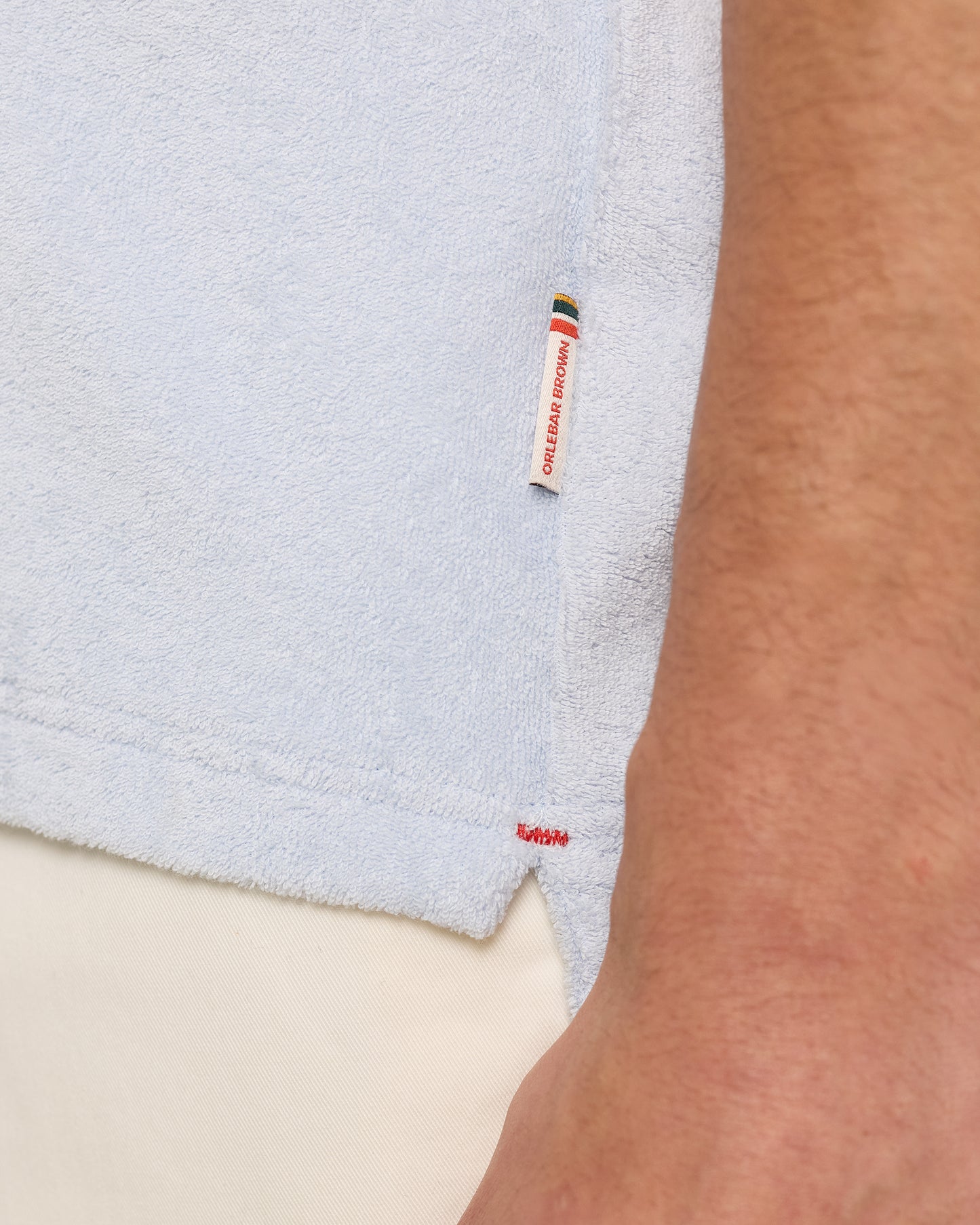 Light blue towel with a brand label on a neutral background