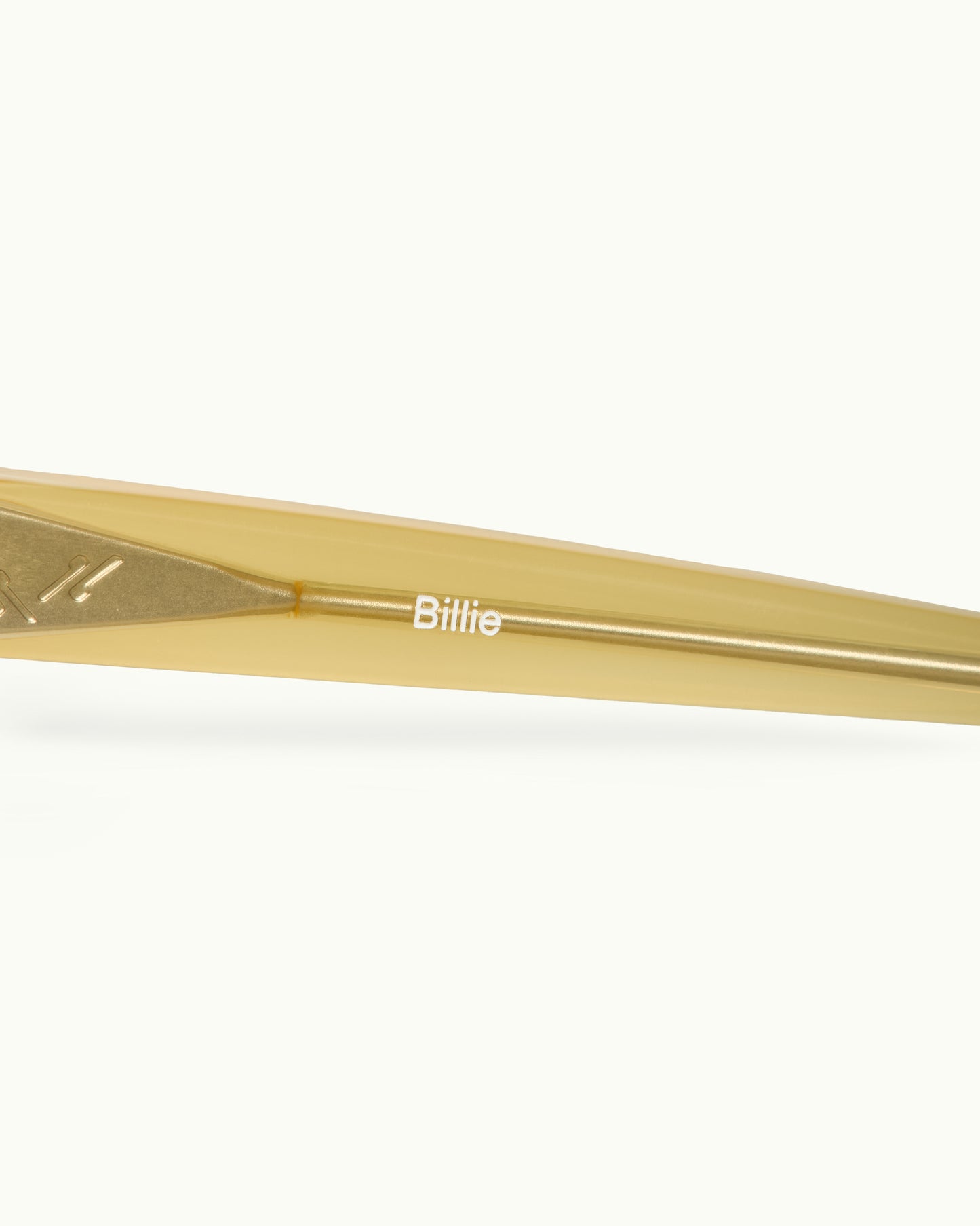 Gold sunglasses with 'Billie' branding on a white background