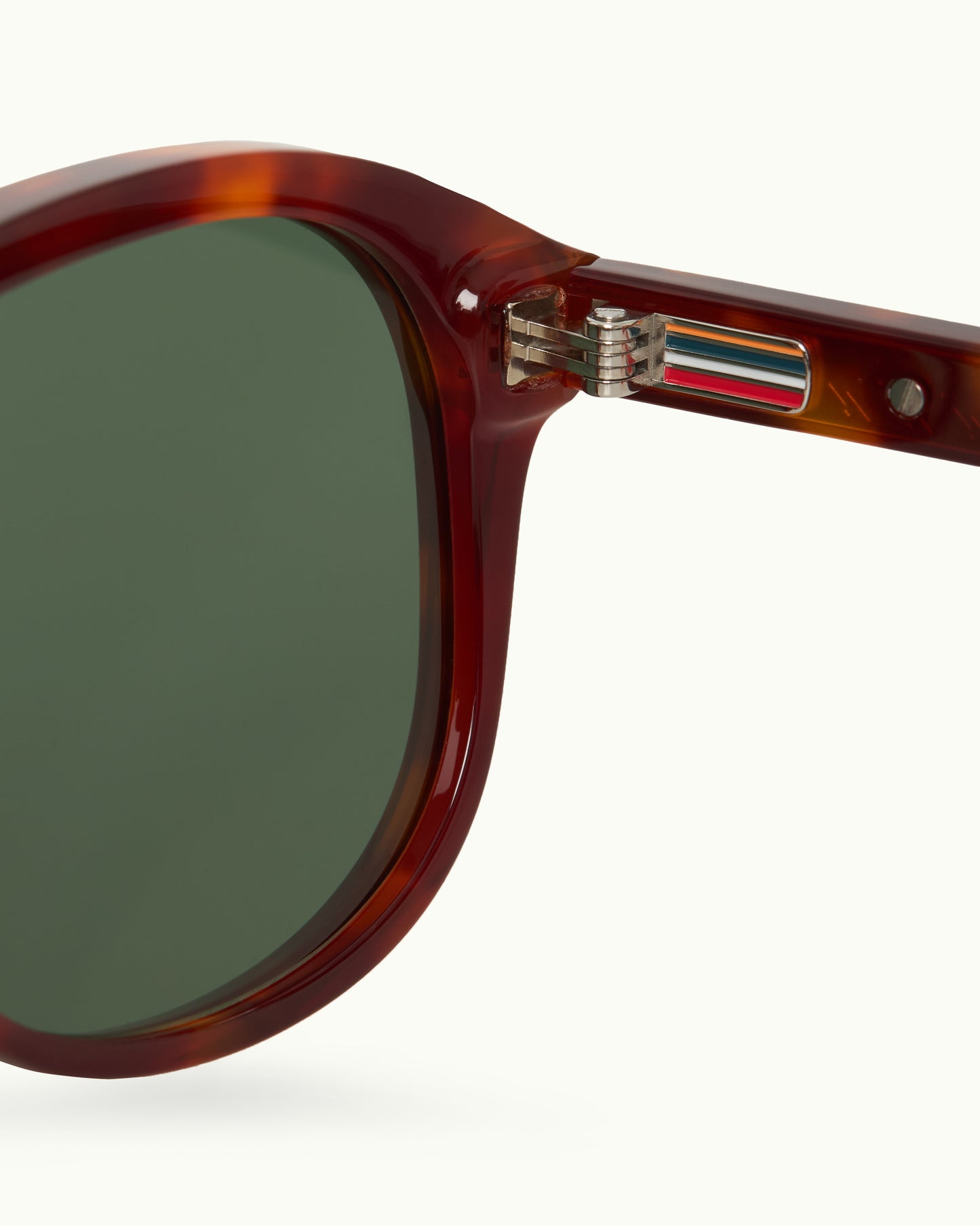 Sunglasses with tortoiseshell frame and green lenses on a white background