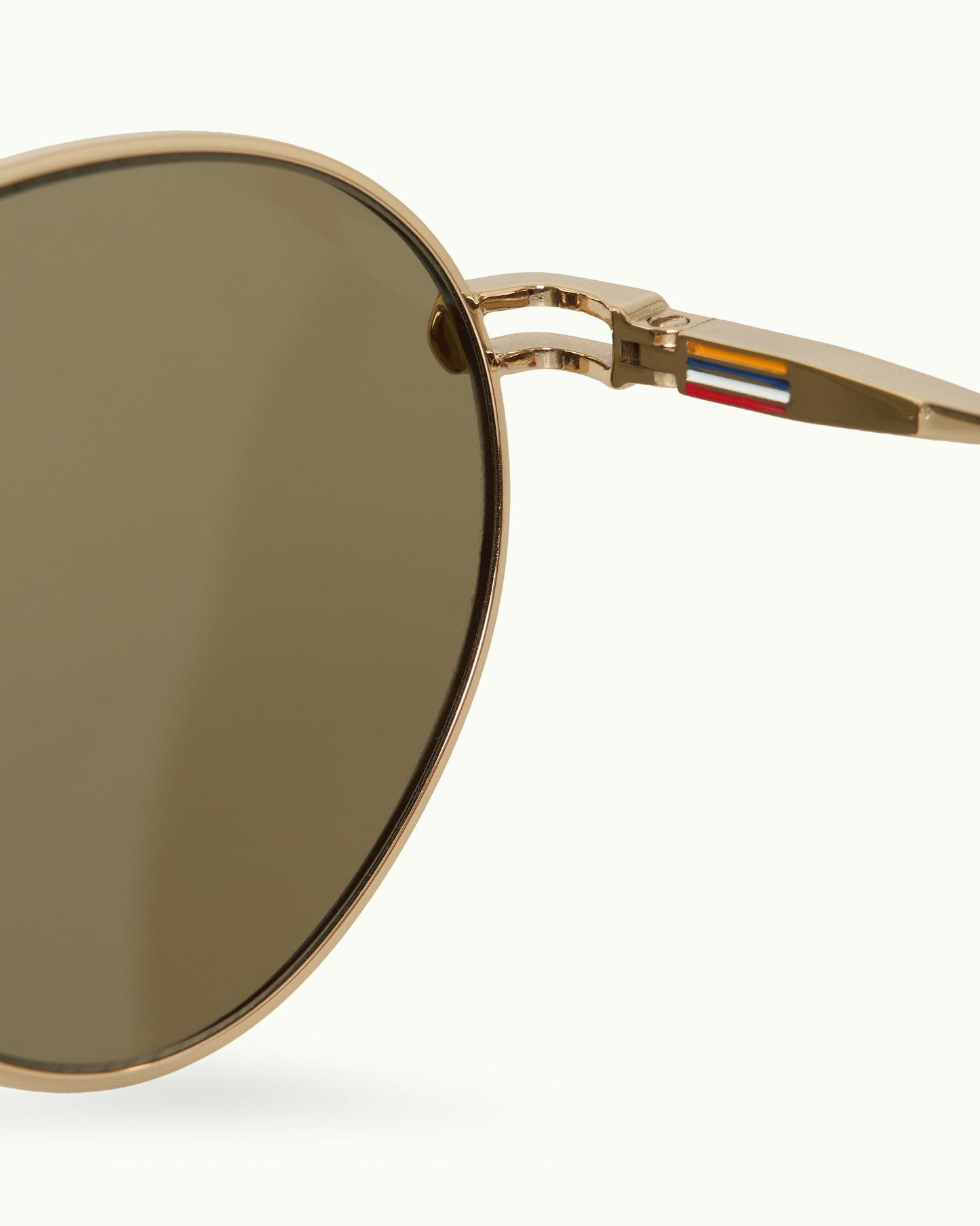 Gold-framed sunglasses with a brand logo on a white background