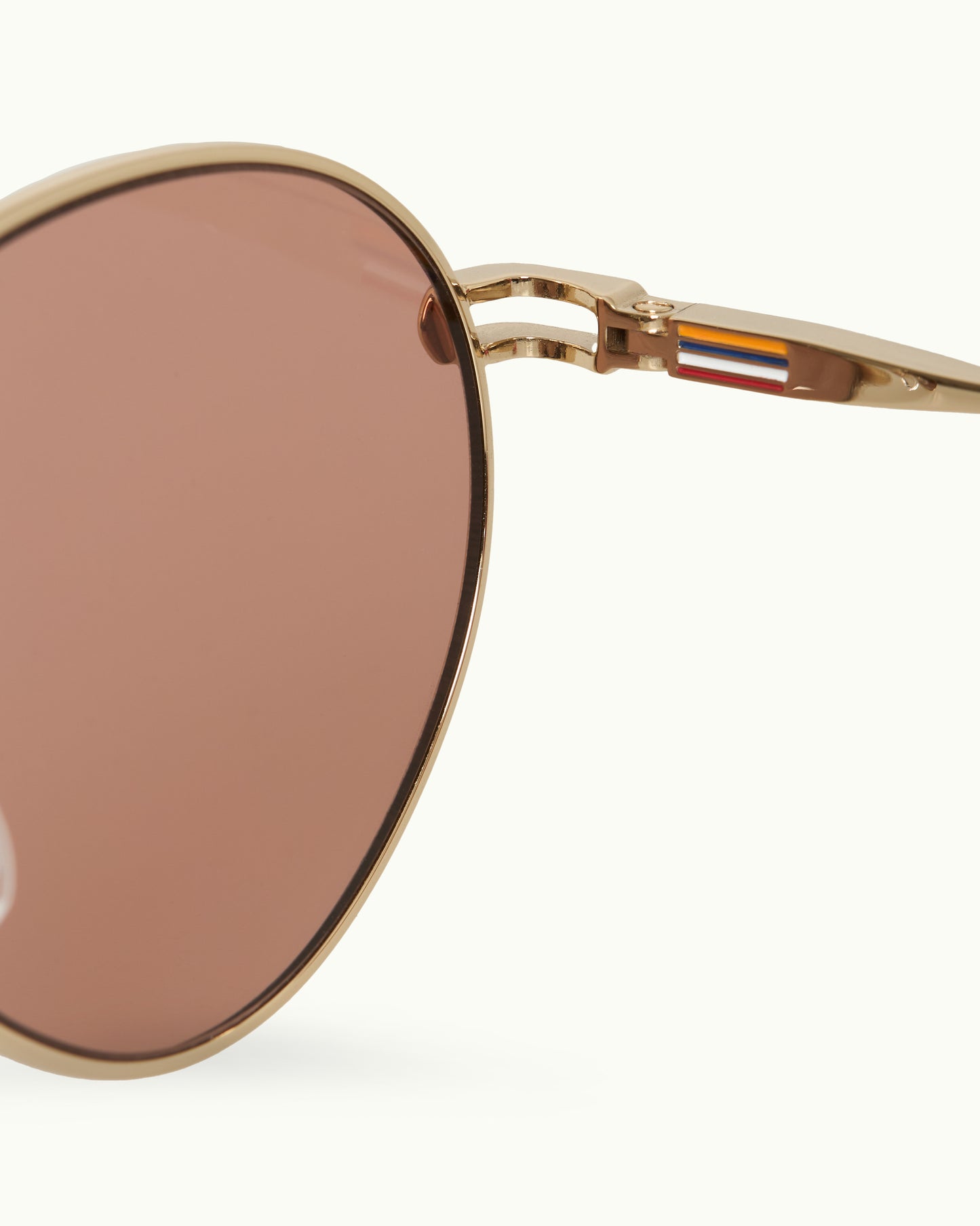 Sunglasses with gold frame and brown lenses on a white background