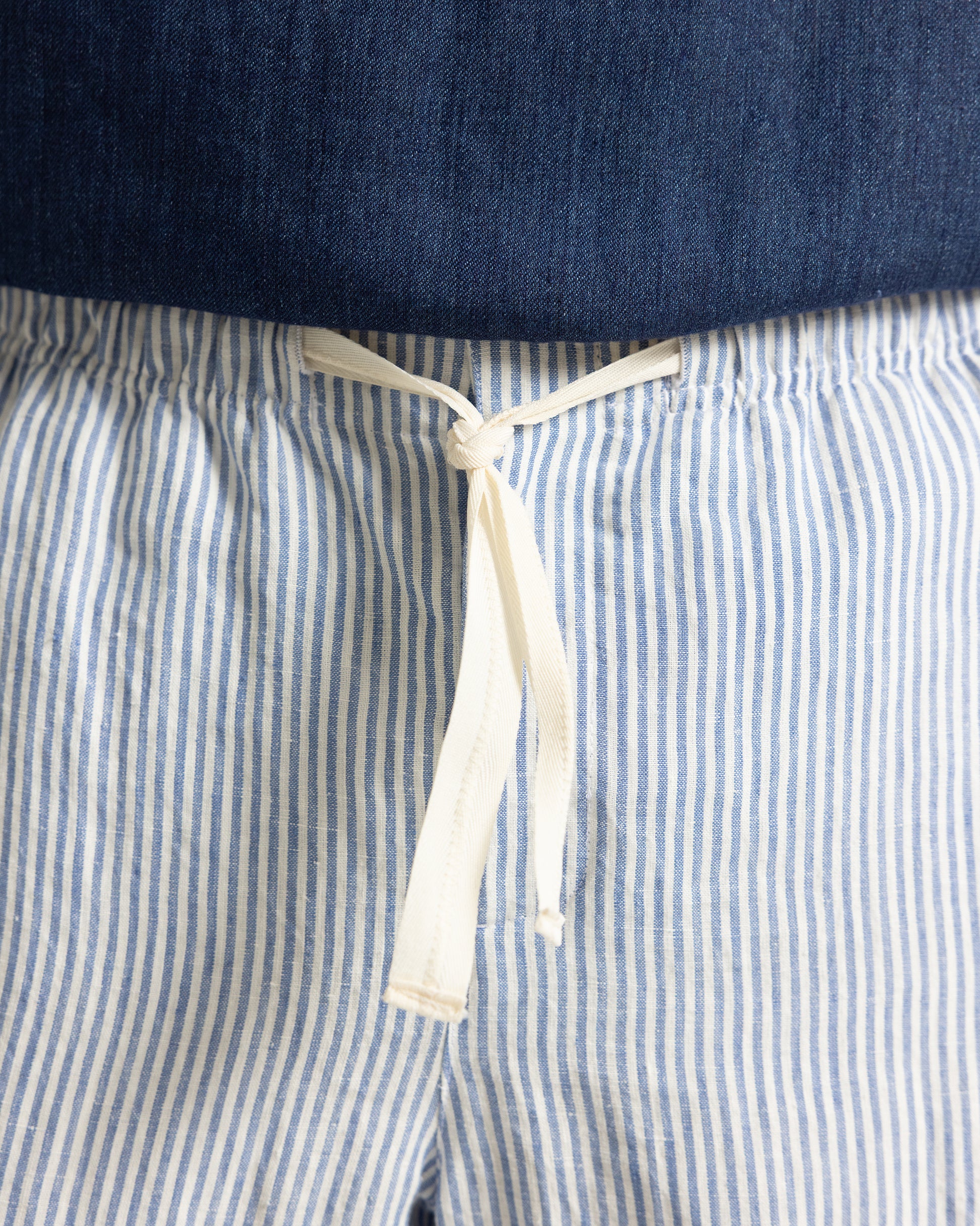 Close-up of blue and white striped pants with a drawstring.