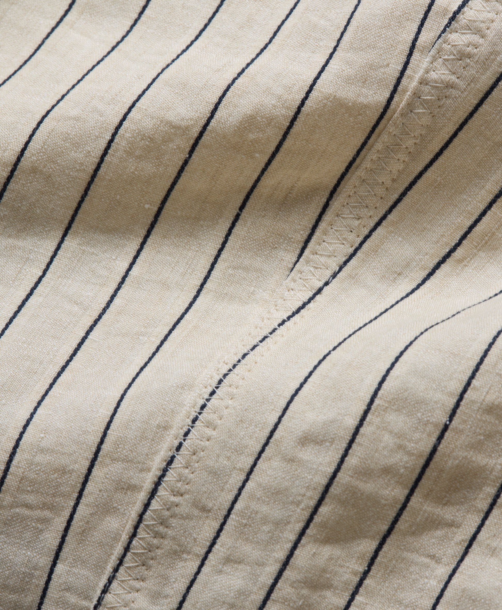 Close-up of beige fabric with blue vertical stripes