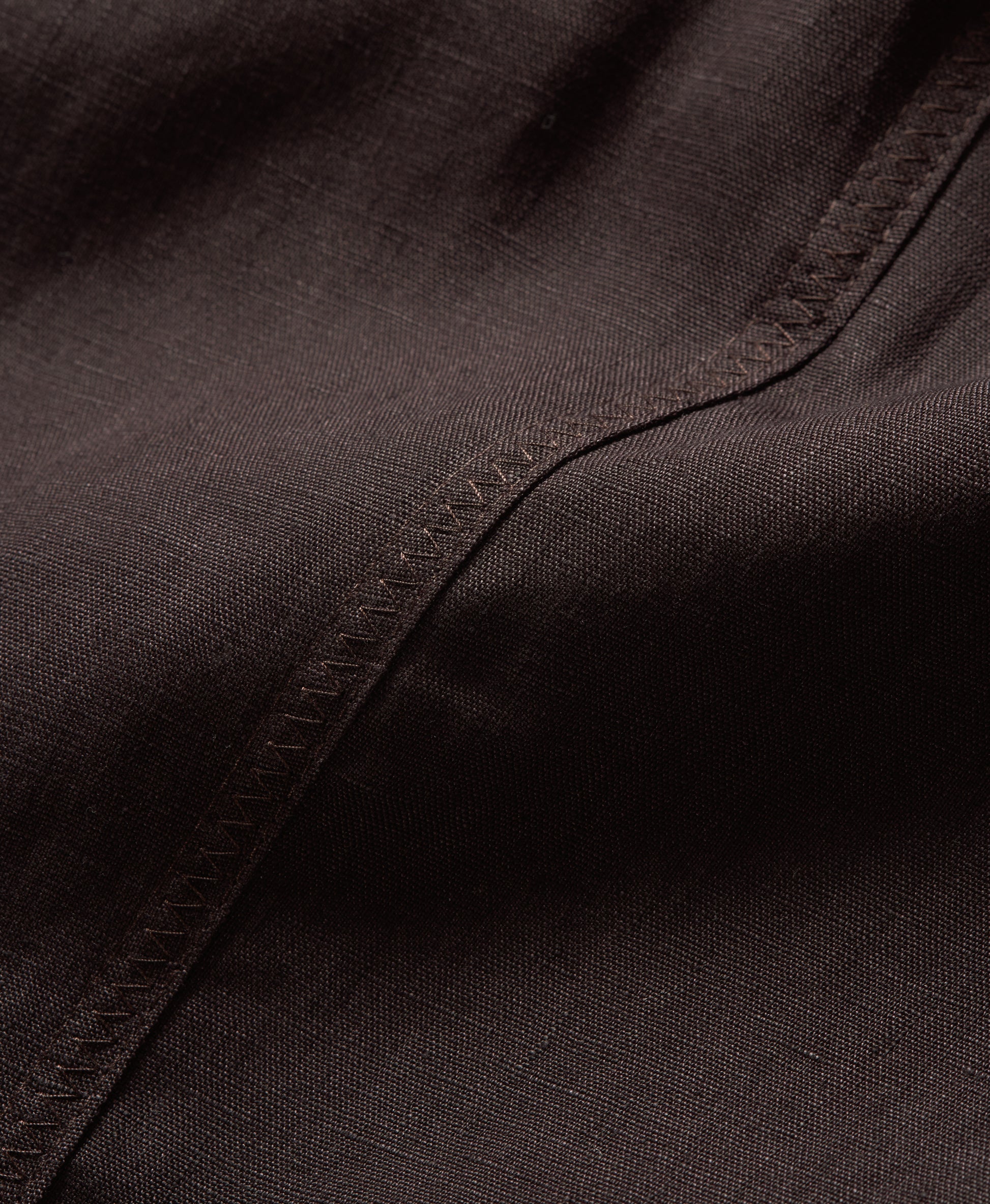 Close-up of dark brown fabric with visible stitching