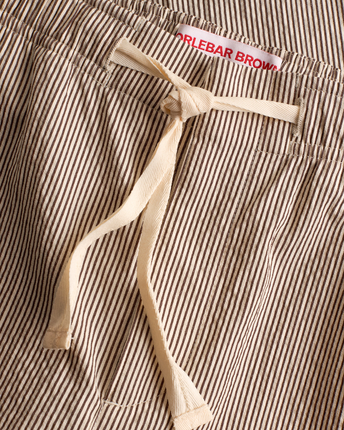 Close-up of an espresso-and-white striped drawcord-waist trousers