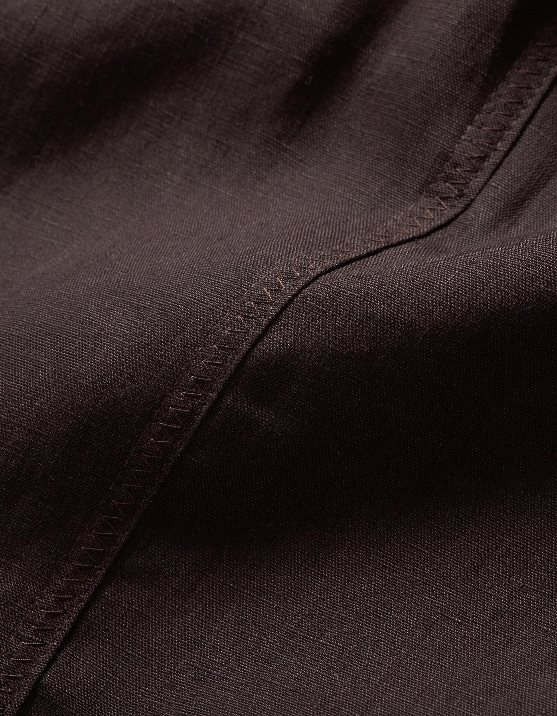 Close-up of dark brown fabric with visible stitching