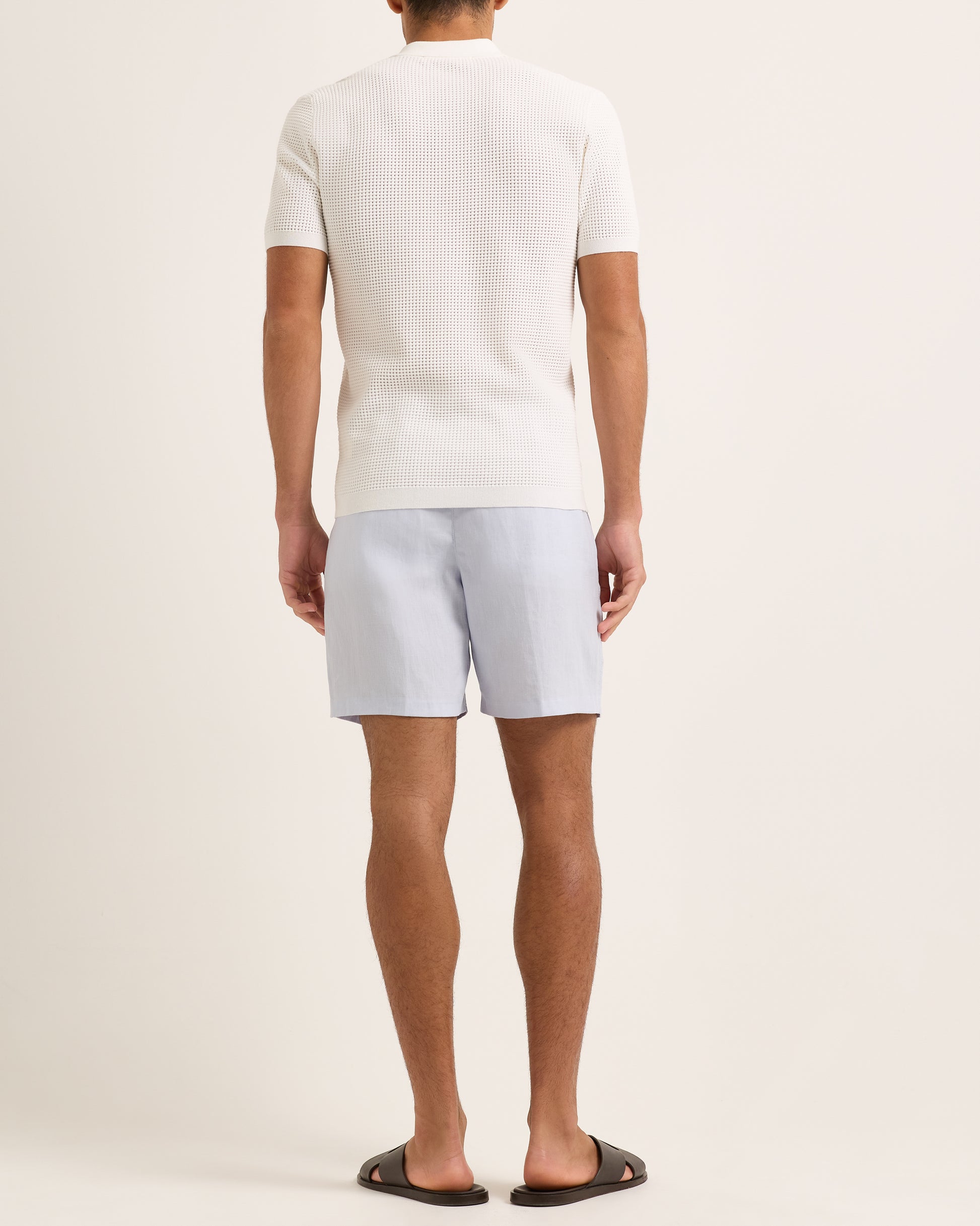 Light blue shorts with a tie waist worn by a person, featuring a white textured polo.