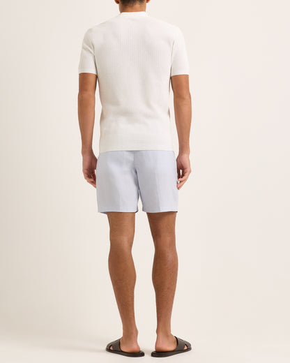 Light blue shorts with a tie waist worn by a person, featuring a white textured polo.