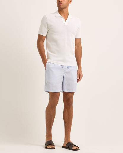 Light blue shorts with a tie waist worn by a person, featuring a white textured polo.