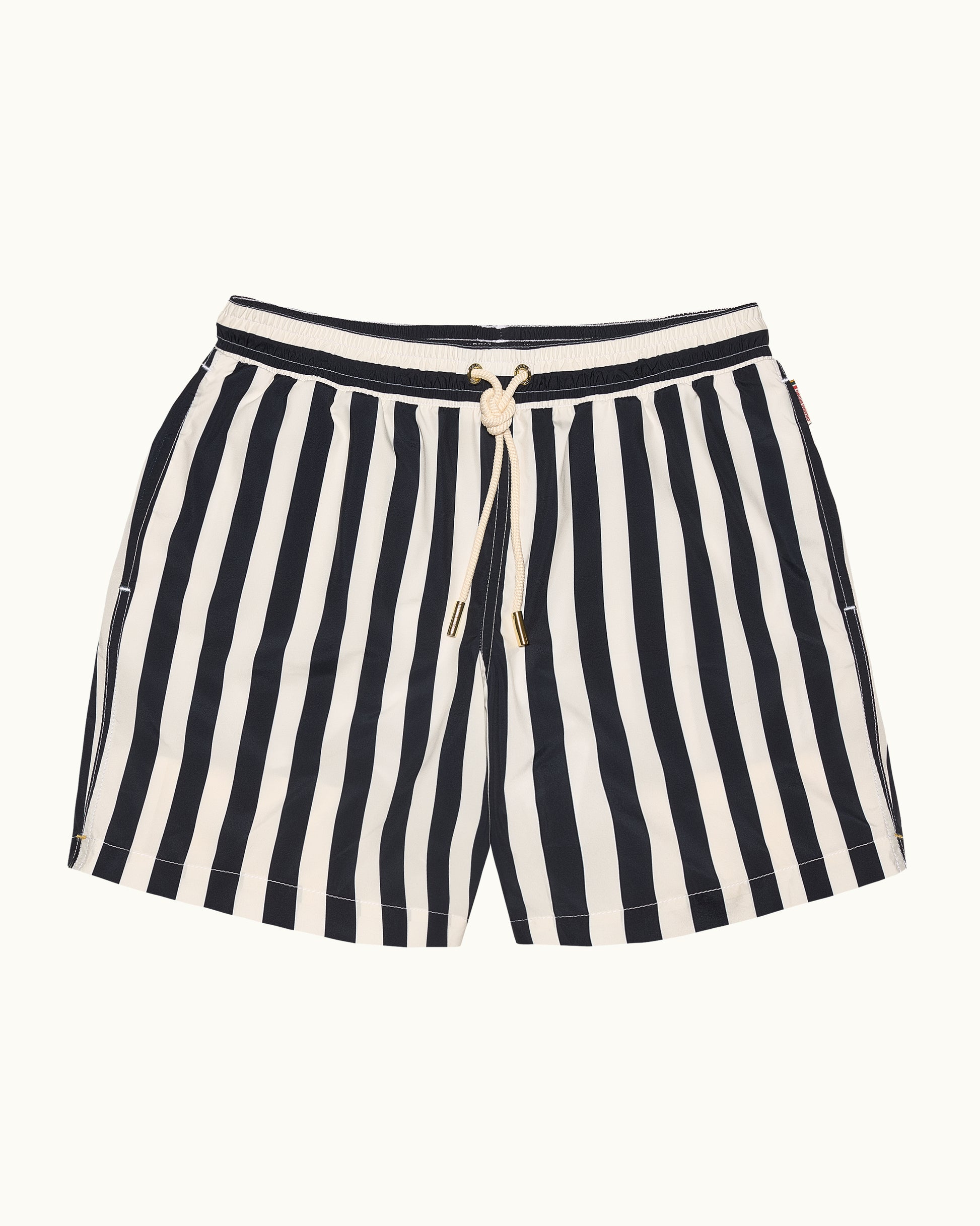 Black and white striped shorts with a drawstring on a beige background