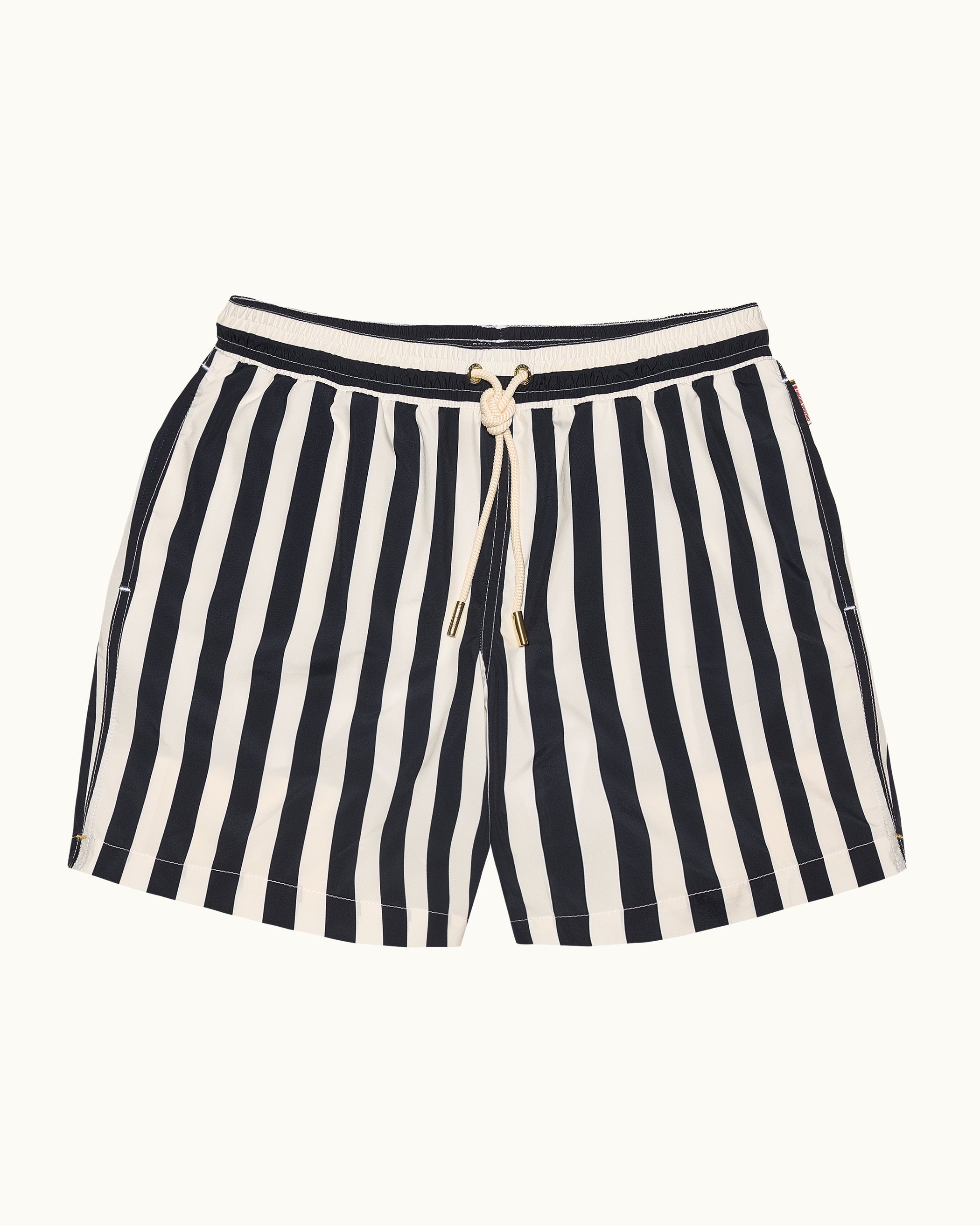 Black and white striped shorts with a drawstring on a beige background