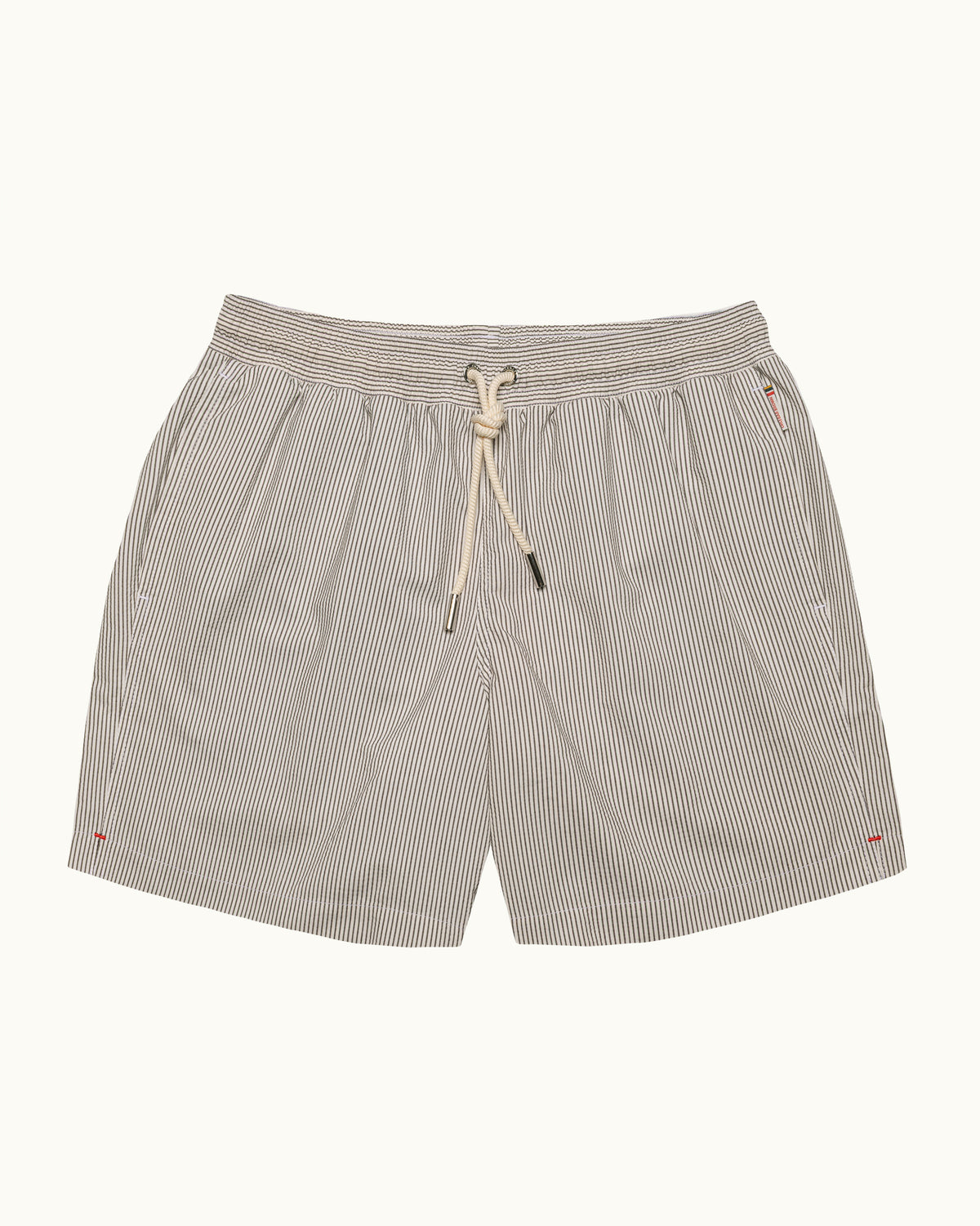A pair of men's casual shorts featuring a fine vertical pinstripe pattern in beige and white, with a matching beige drawstring at the elastic waistband, shown against a solid off-white background.