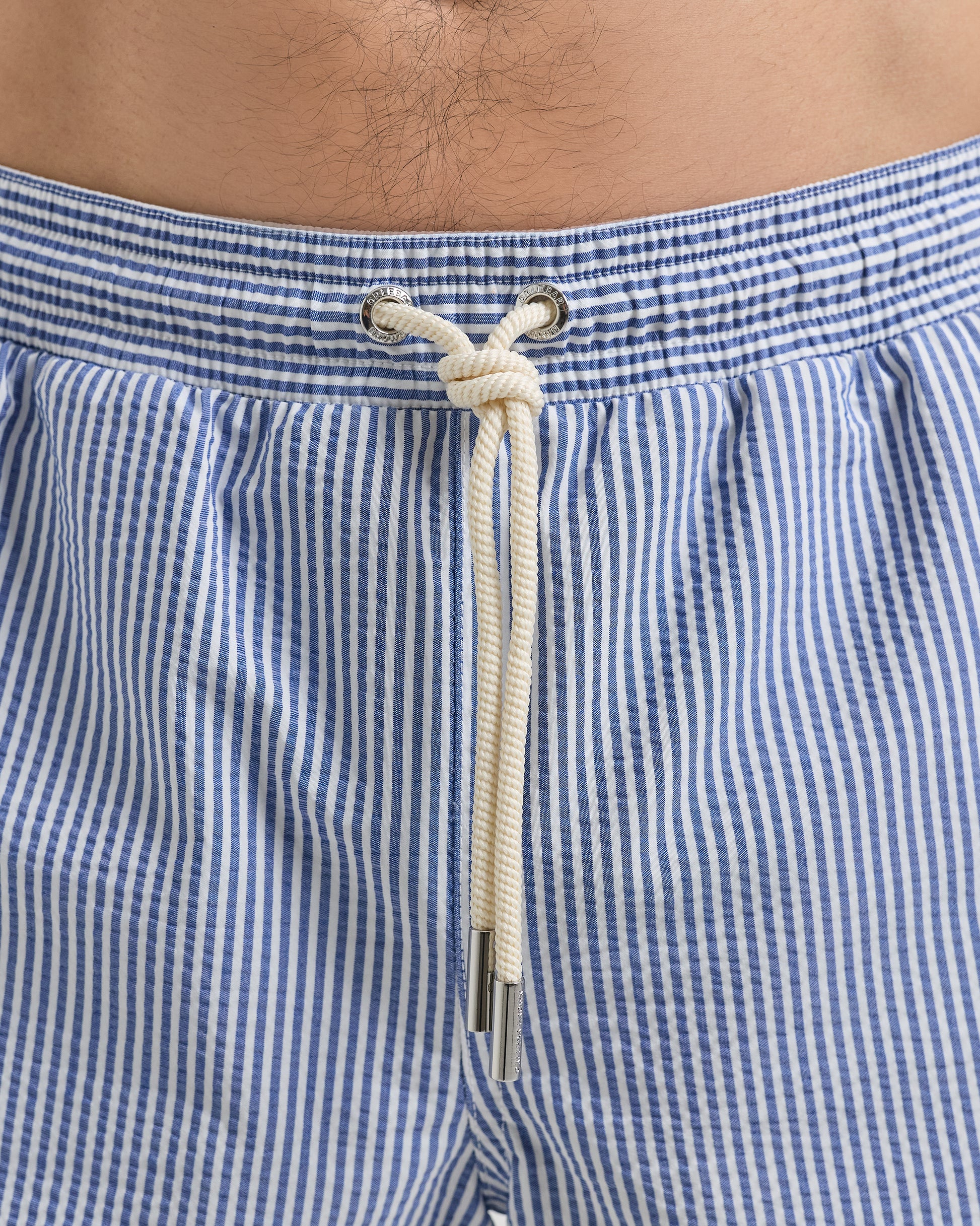 Close-up of blue and white checkered swim shorts with a rope tie.