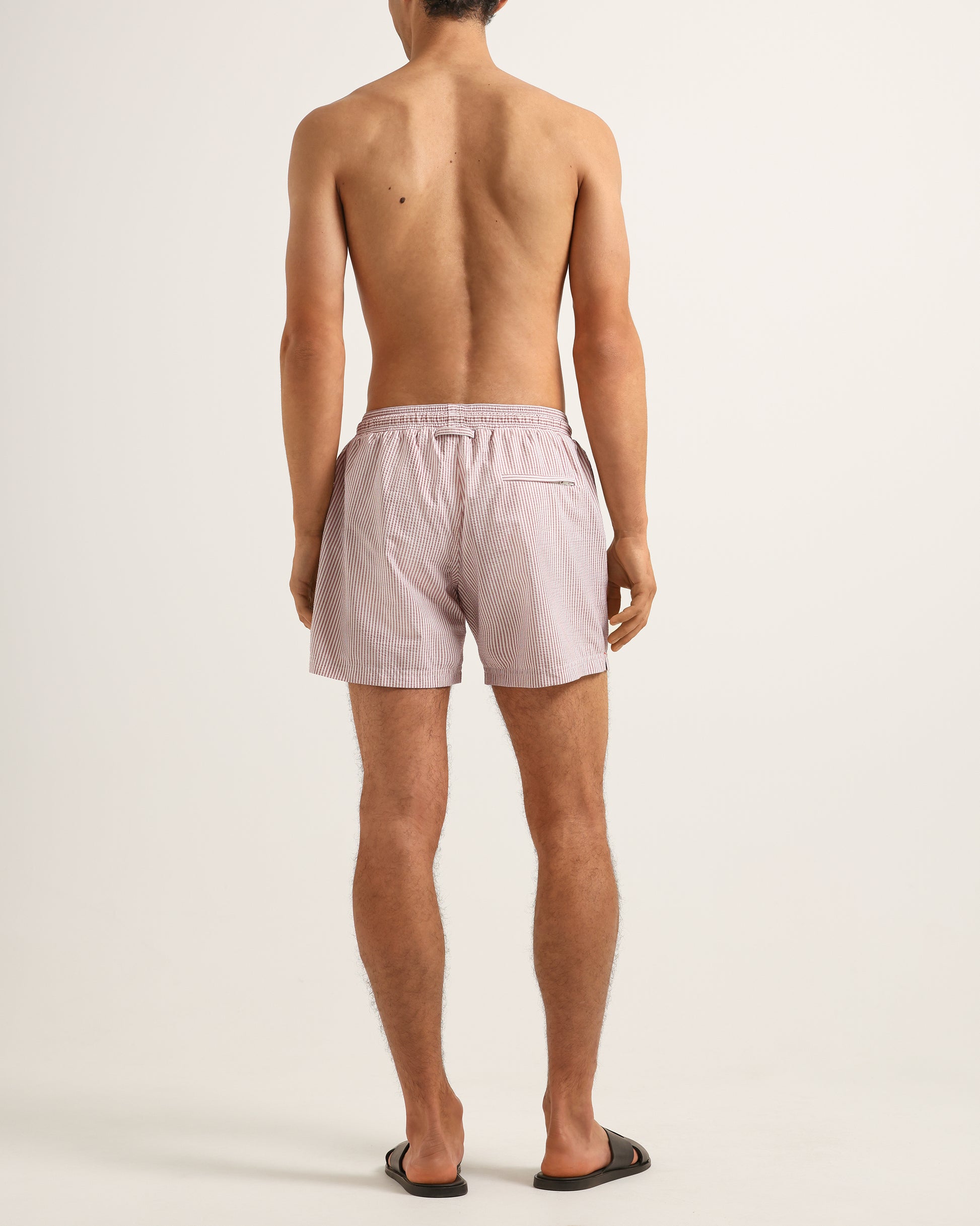 Person wearing light pink shorts on a white background