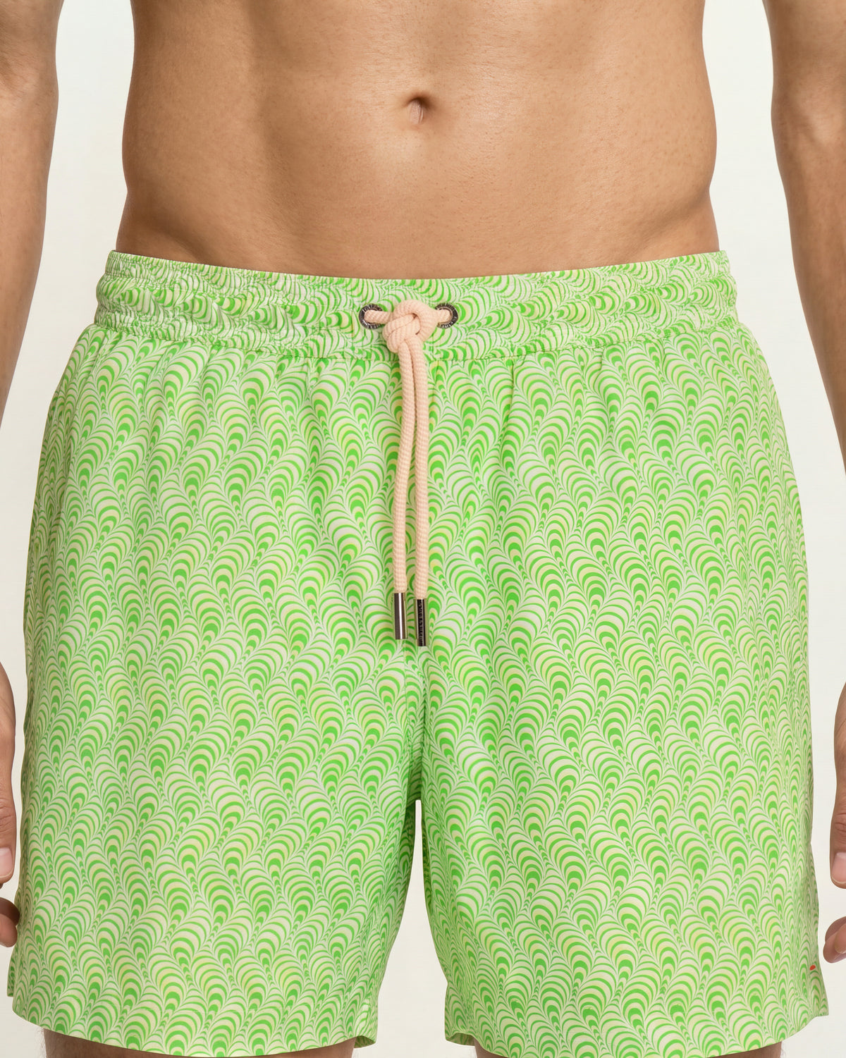 Close-up of man wearing  light green drawcord swim shorts o a white background