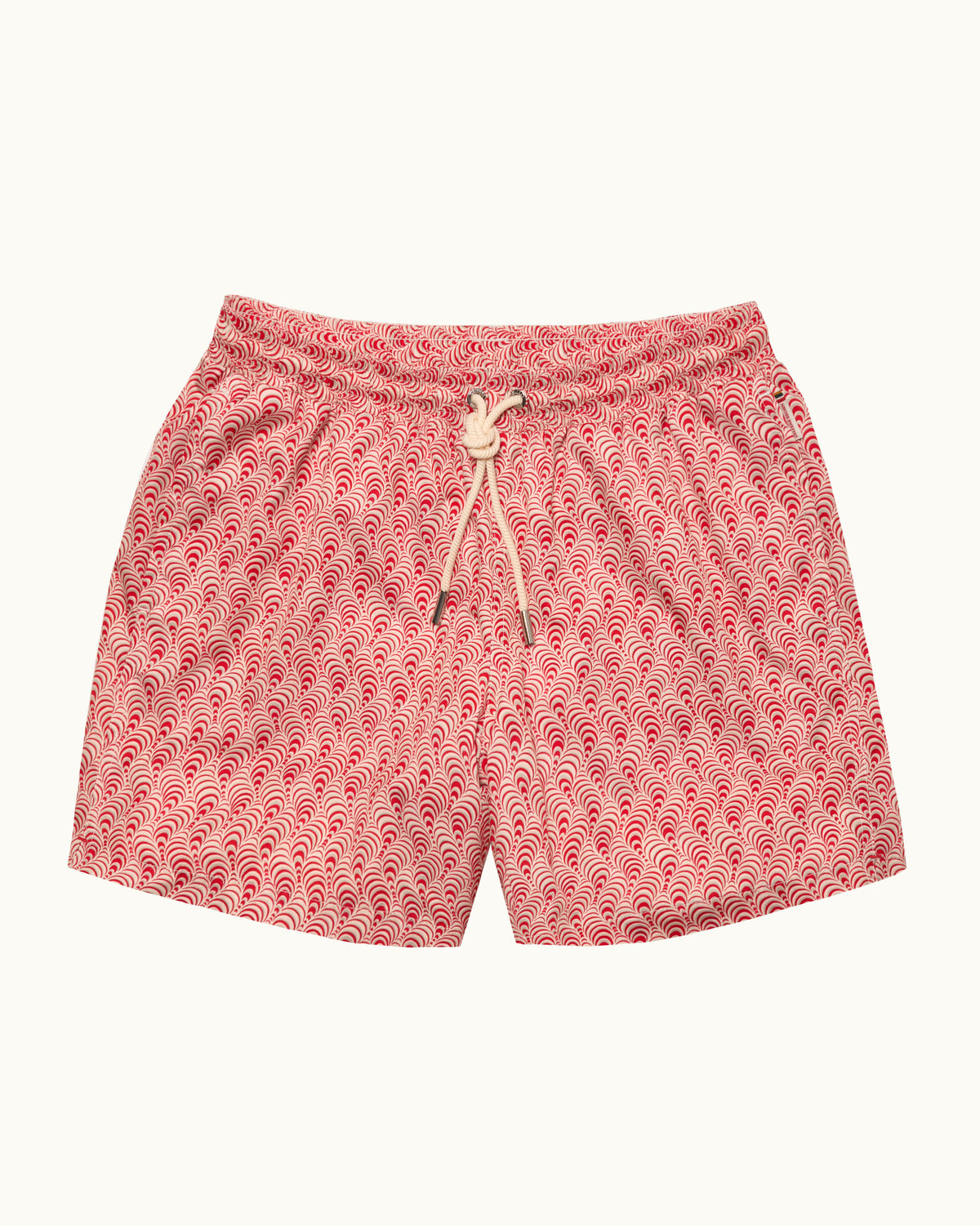 Red patterned swim shorts on a plain background