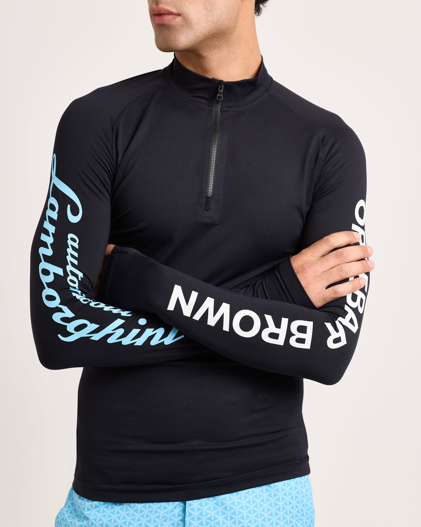 Person wearing a black long-sleeve shirt with Lamborghini branding on sleeves against a neutral background