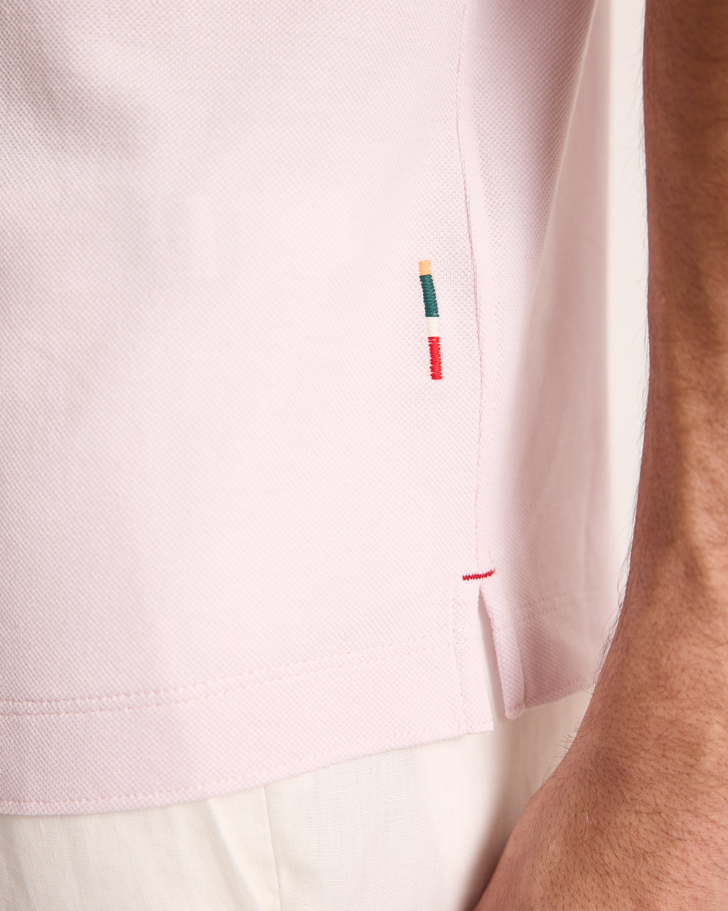 Close-up of a light pink shirt with embroidered details on a blurred background