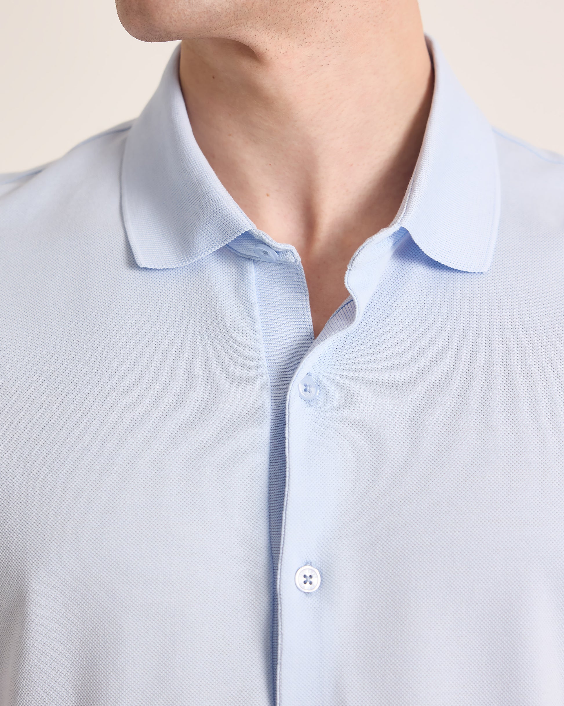Closeup of light blue polo shirt with collar detailing