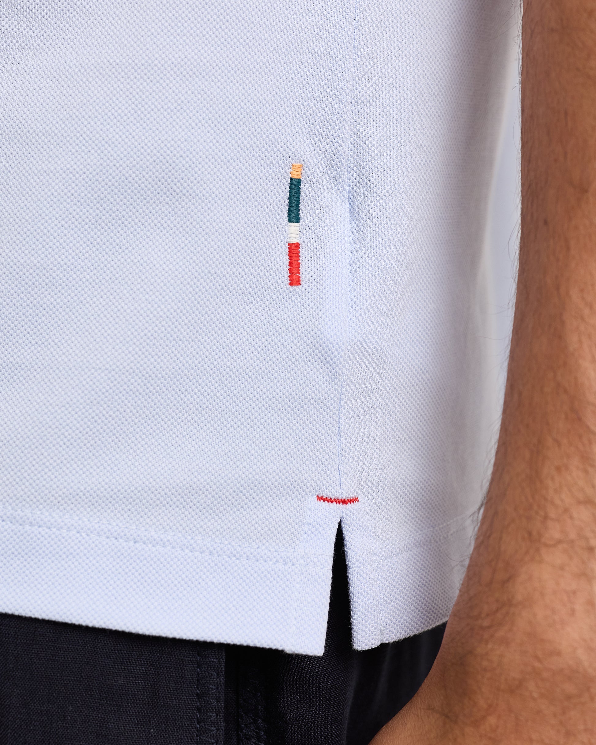 Blue polo with texture and logo woven into side