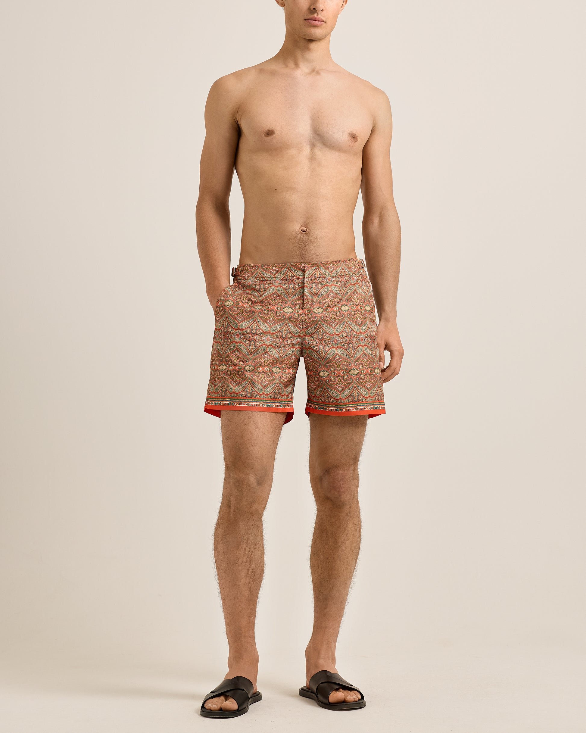 Man wearing patterned shorts on a beige background