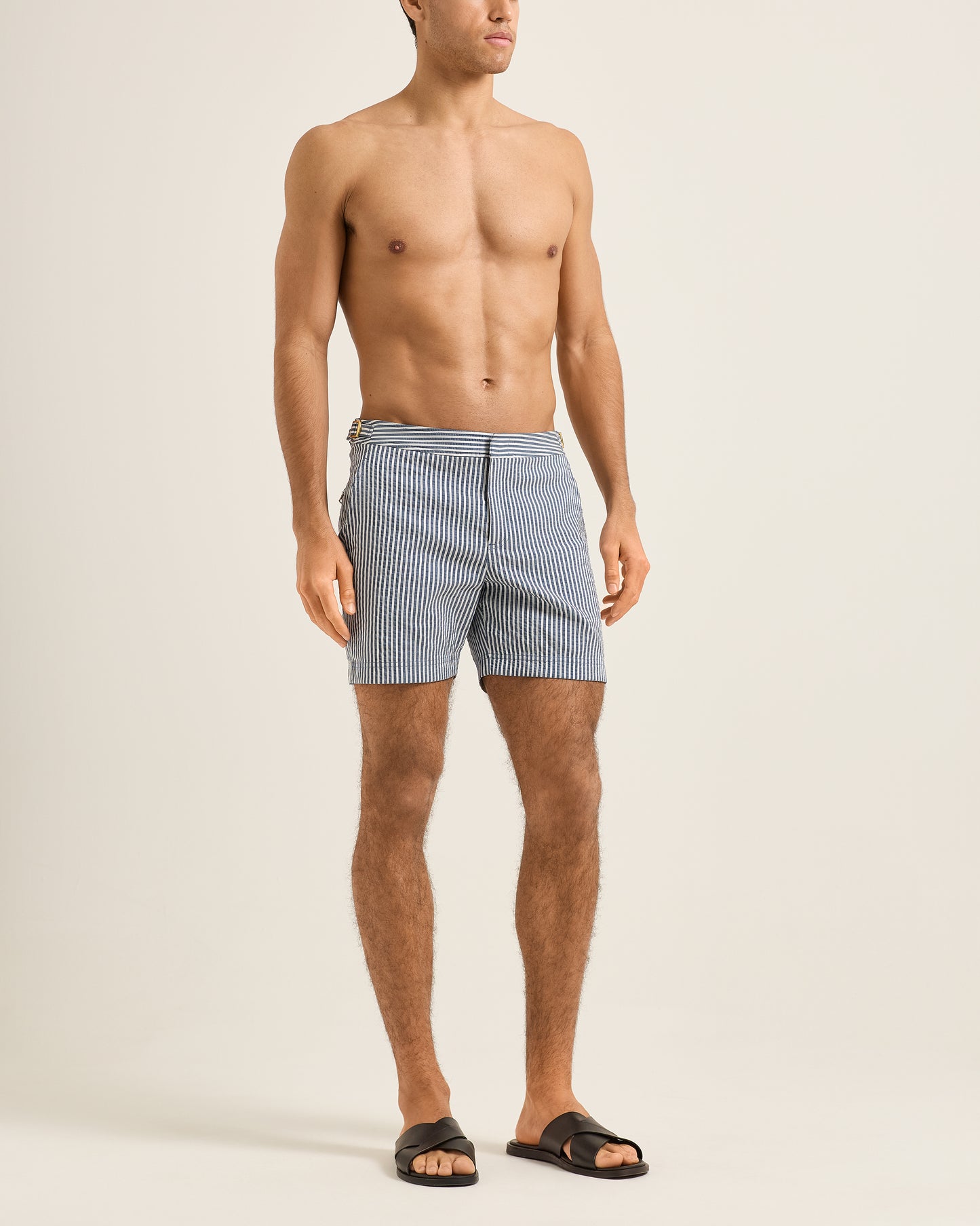 Man wearing blue checkered shorts on a beige background