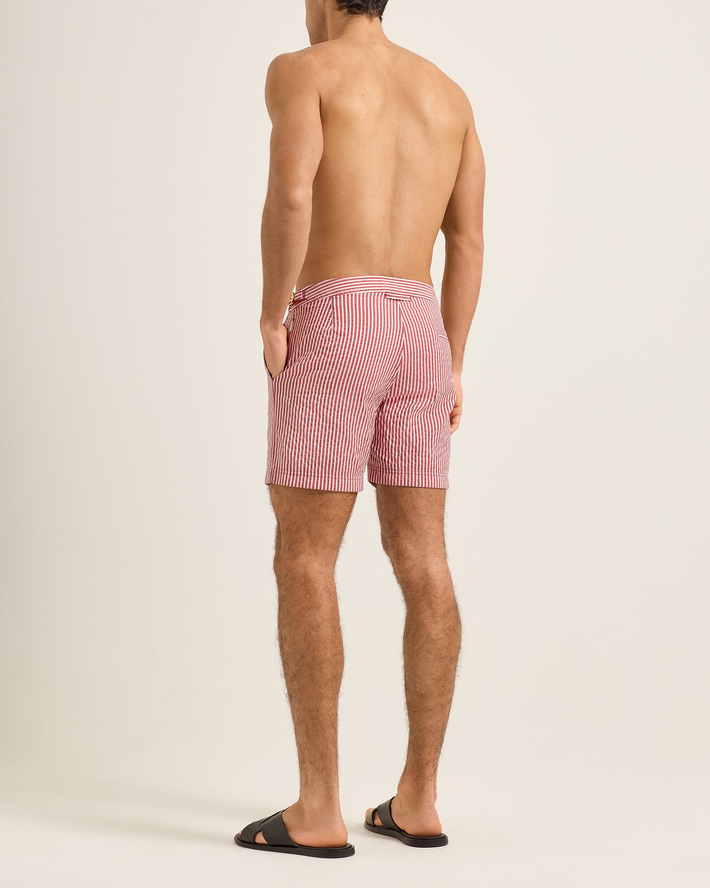 Man wearing pink striped shorts on a beige background