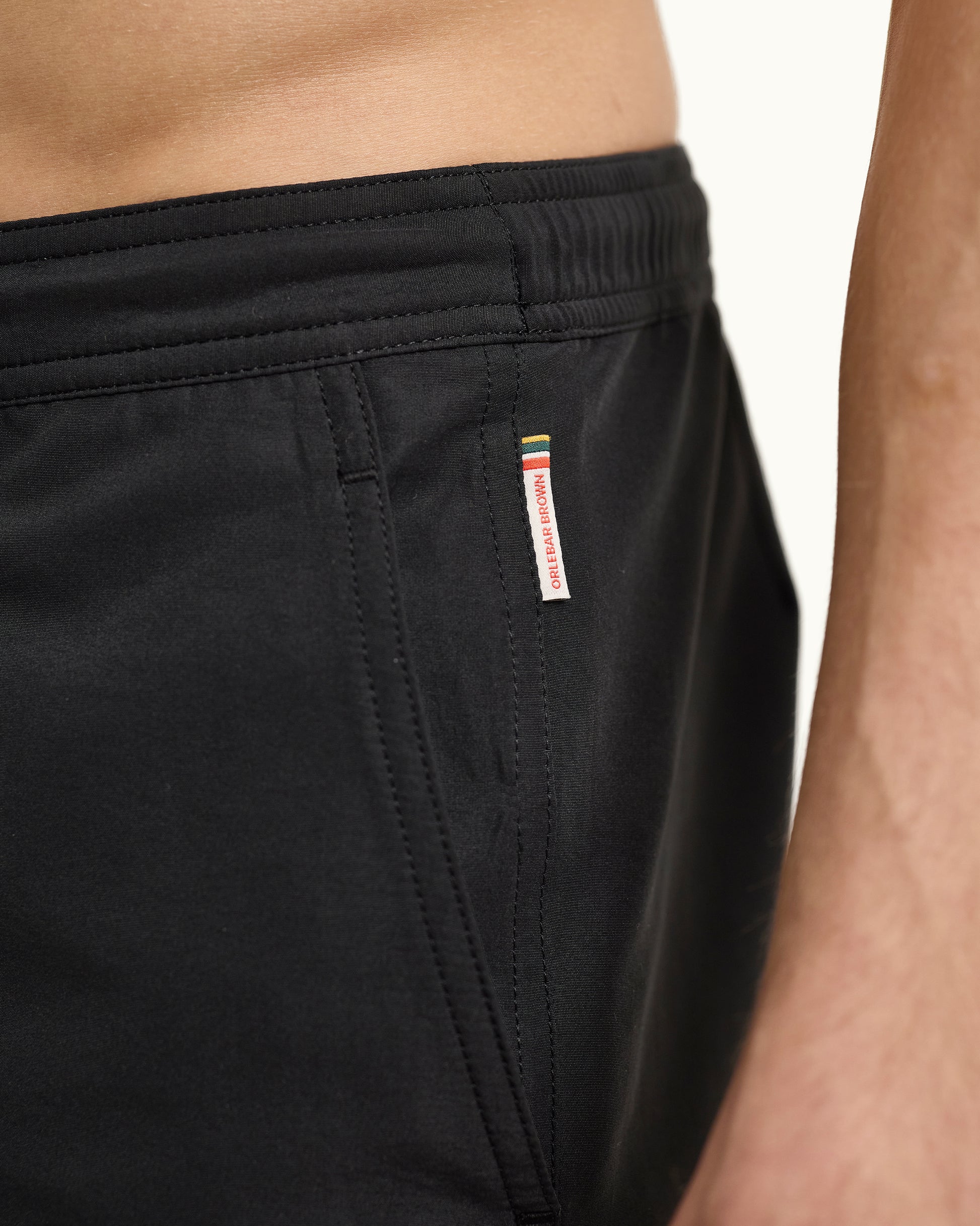 Black shorts with a brand label on a neutral background