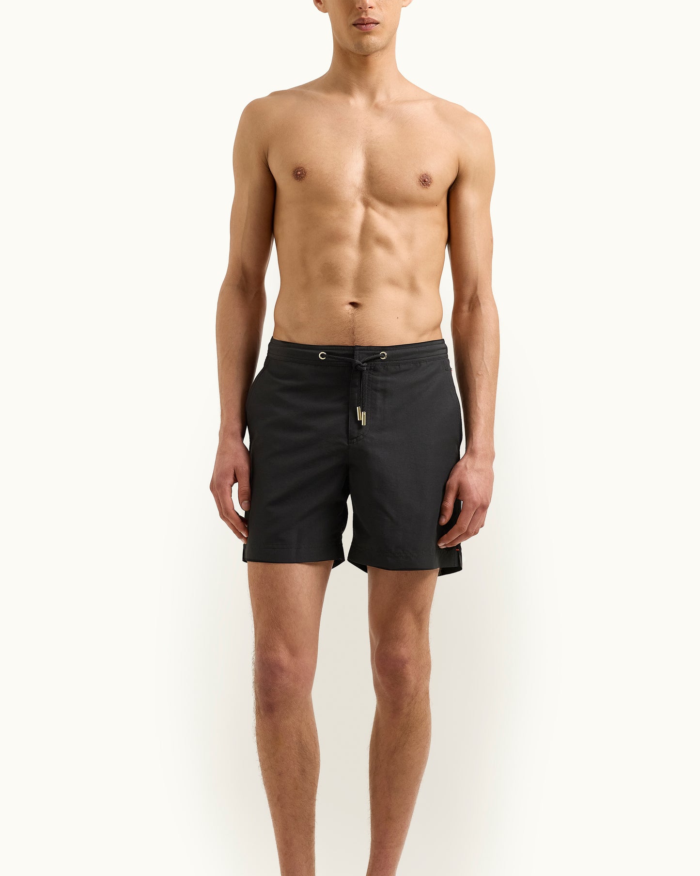 Man wearing black swim shorts on a white background