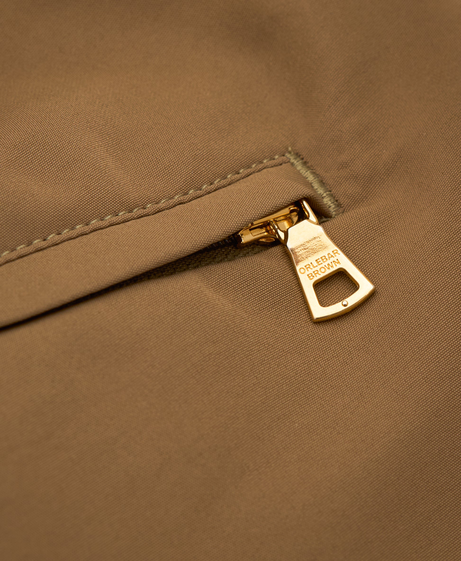 Close-up of a zipper on a brown fabric background