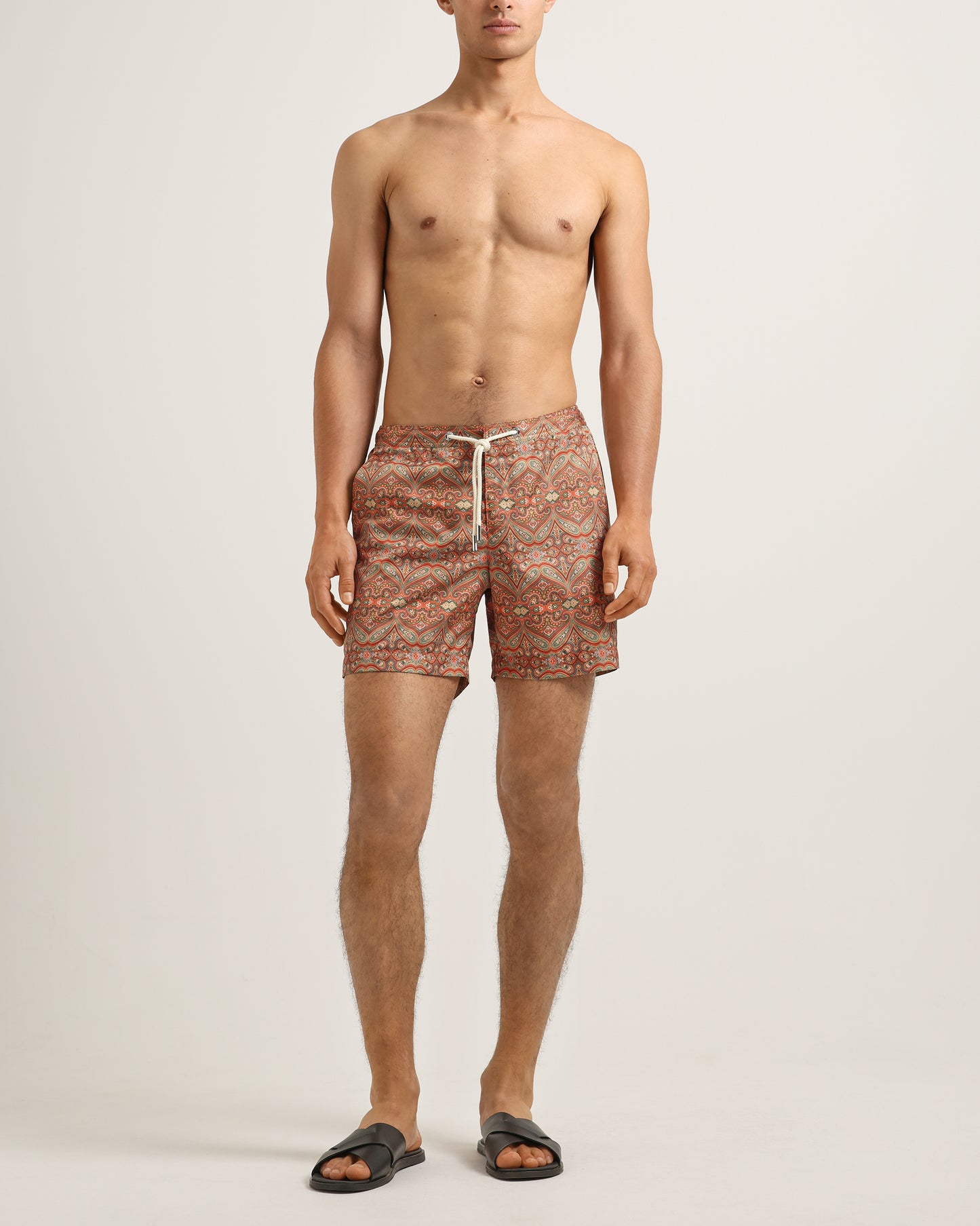 Man wearing patterned shorts on a plain background