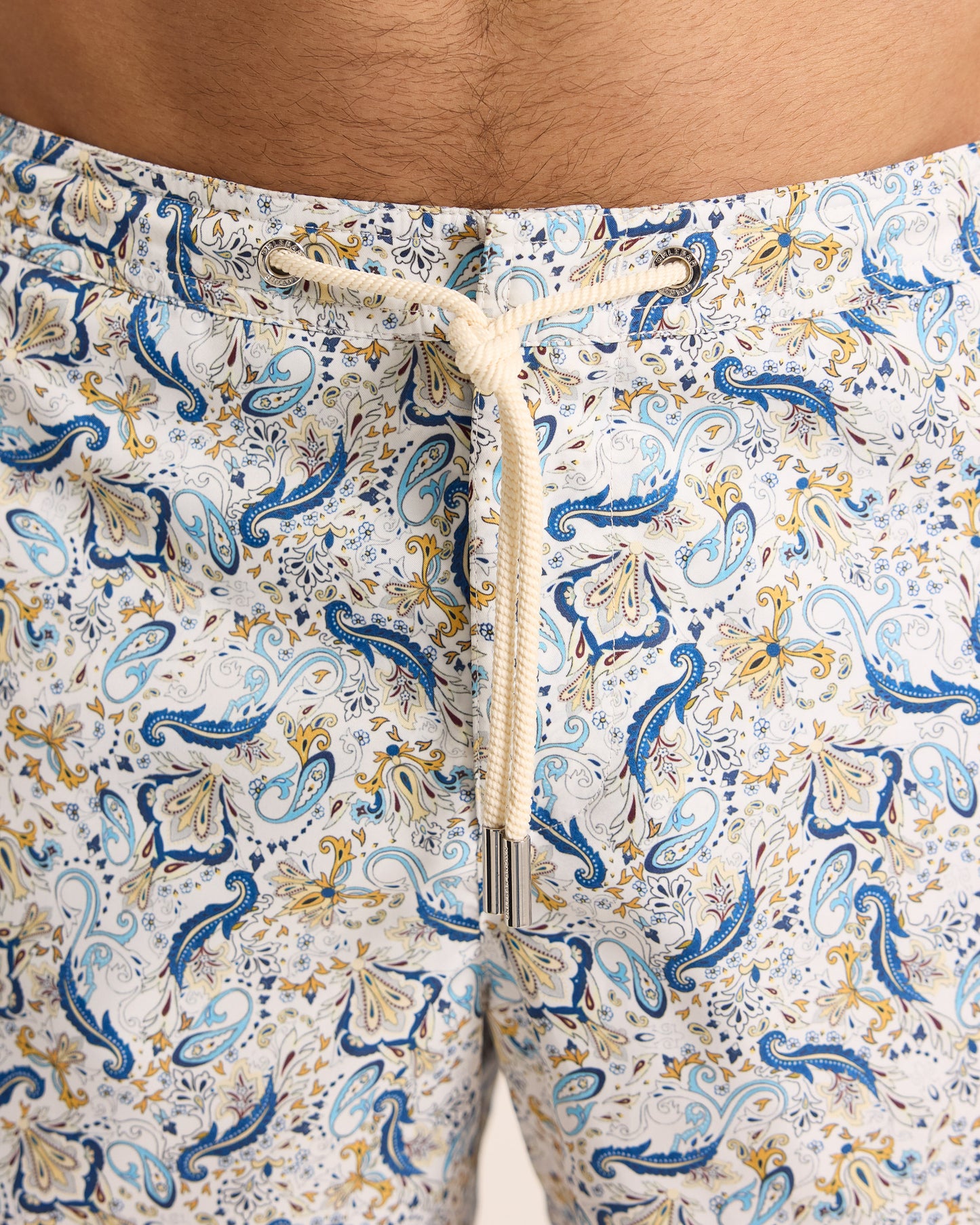 Close-up of patterned shorts with a drawstring on a neutral background