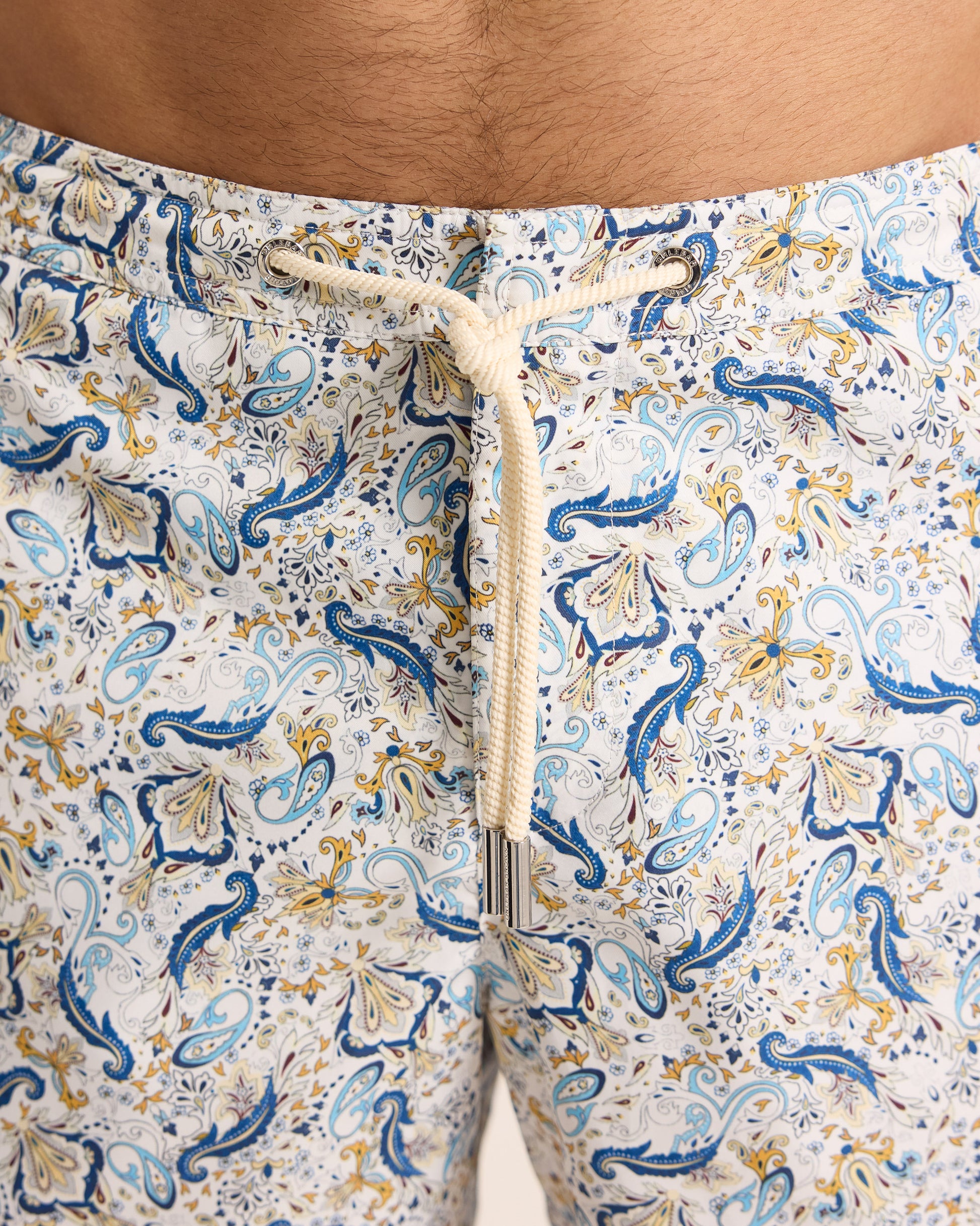 Close-up of patterned shorts with a drawstring on a neutral background