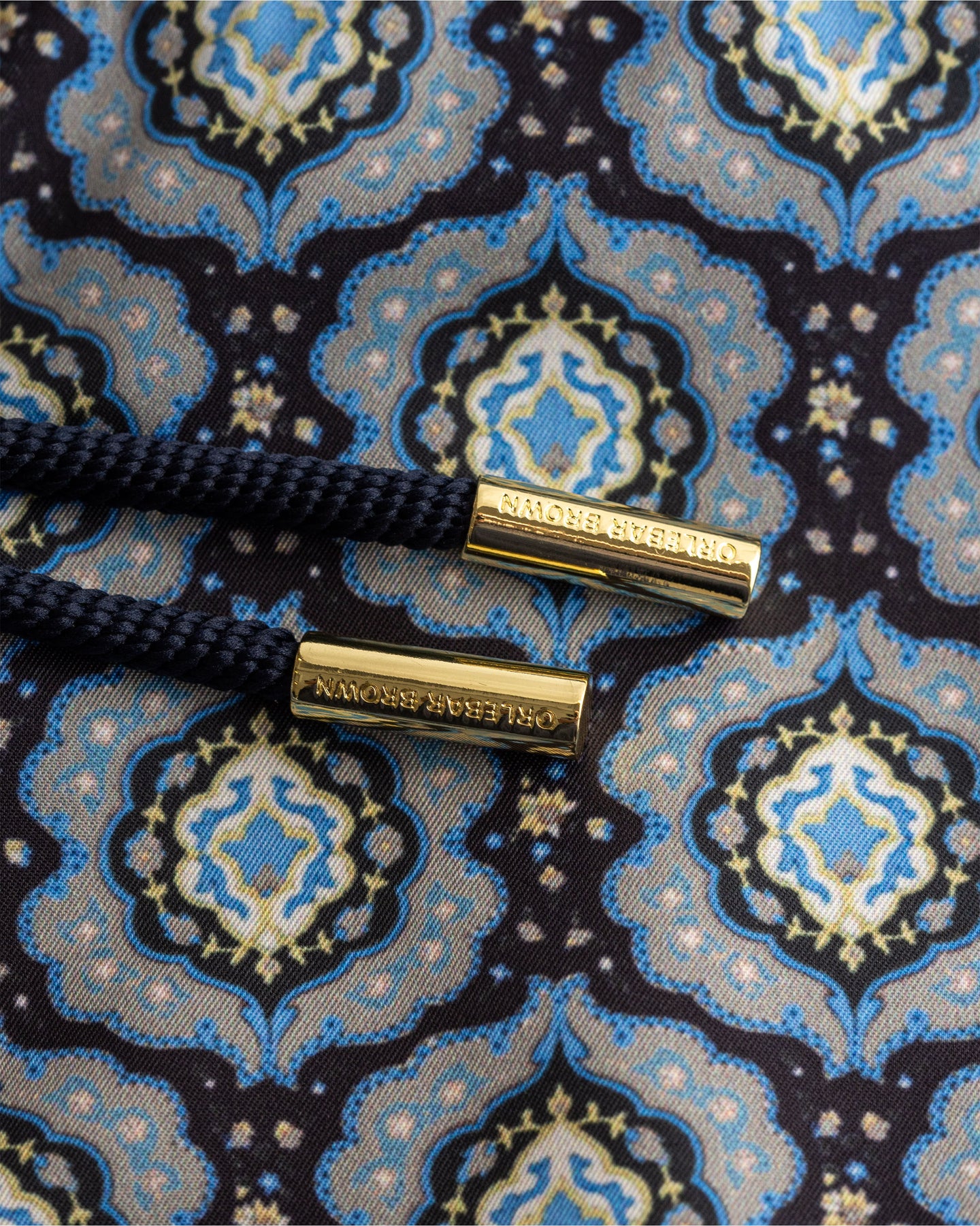 Close-up of a patterned fabric with gold buttons on a blue and black background